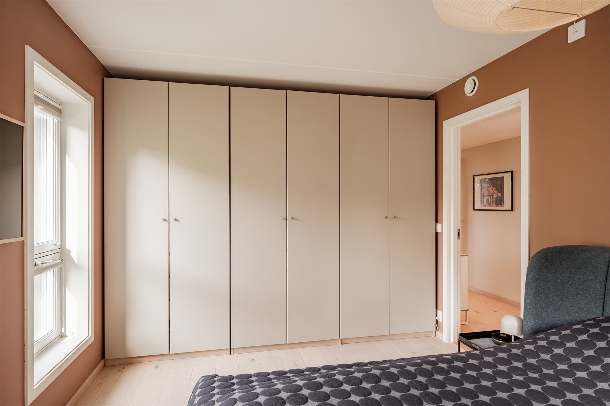 Stort garderobeskap på hele veggen med god plass til oppbevaring av klær, og andre personlige eiendeler.