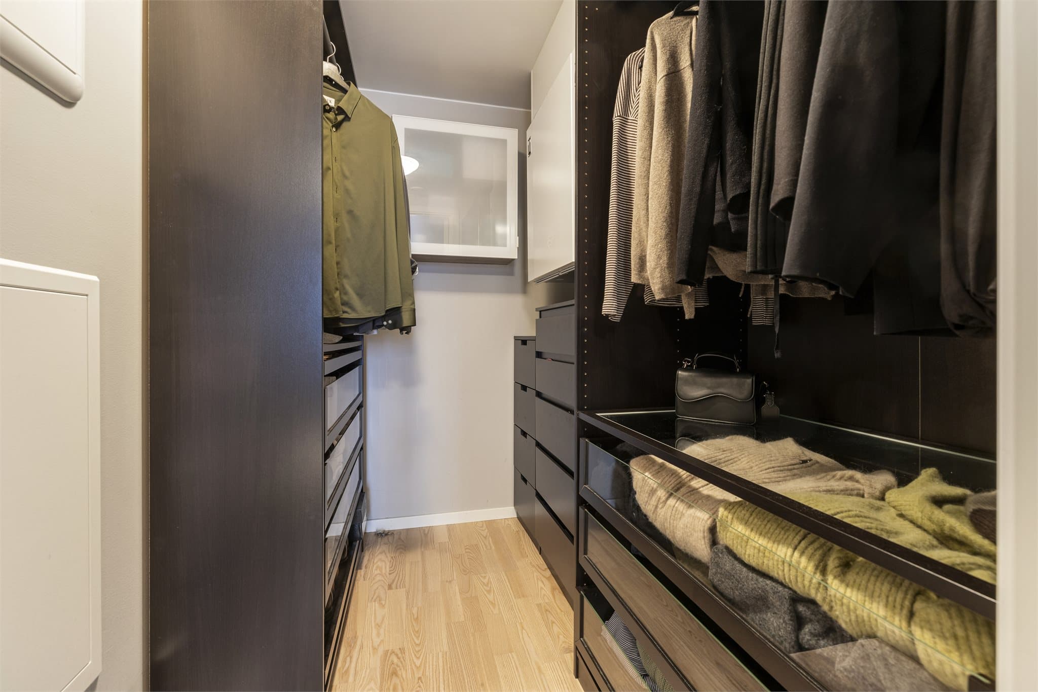 Omkledningsrommet er innredet med en åpen garderobeløsning for optimal oversikt og oppbevaring.