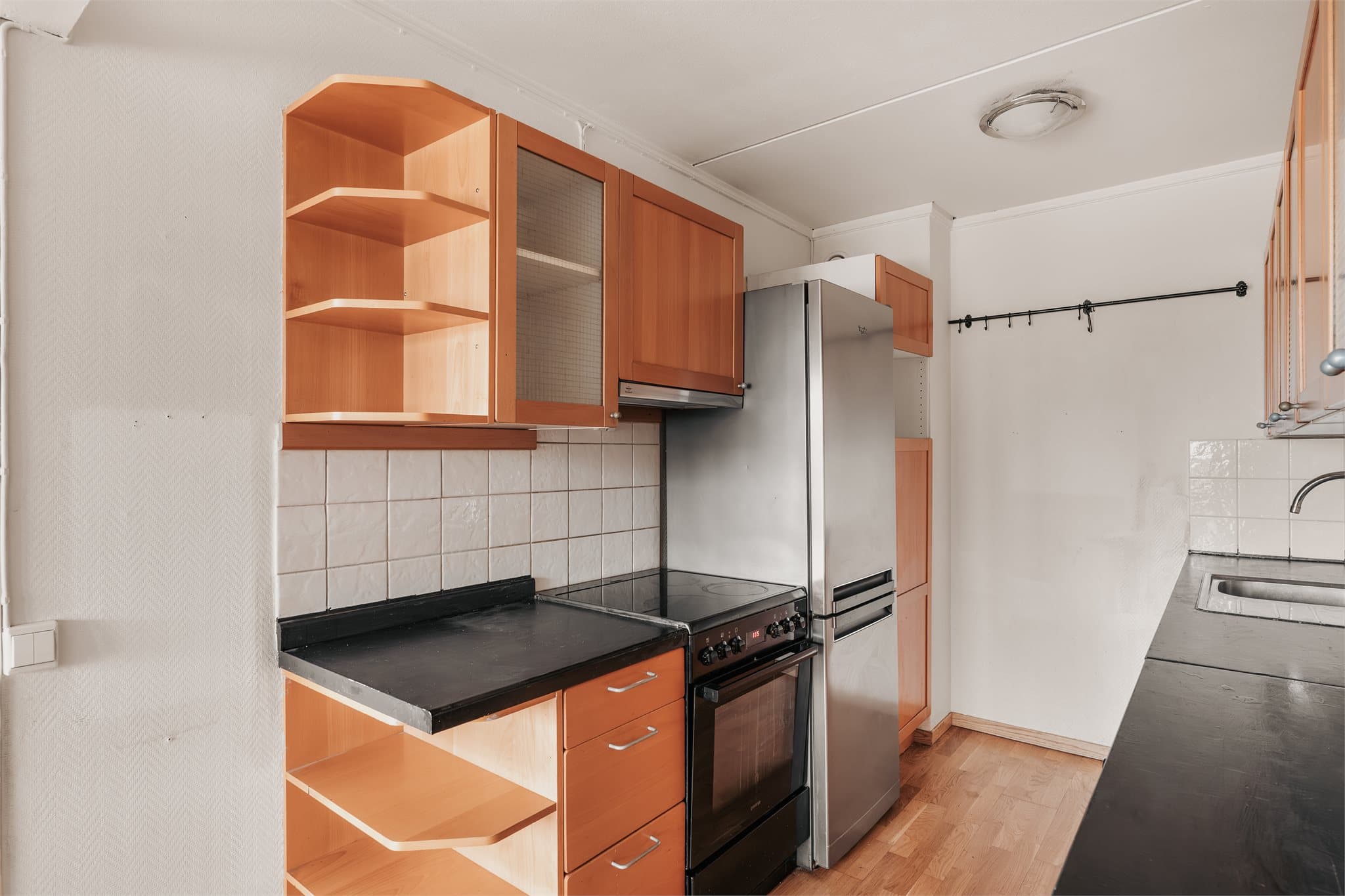 Innredning med glatte fronter og benkeplate i laminat. Kjøleskap, komfyr, oppvaskmaskin medfølger.