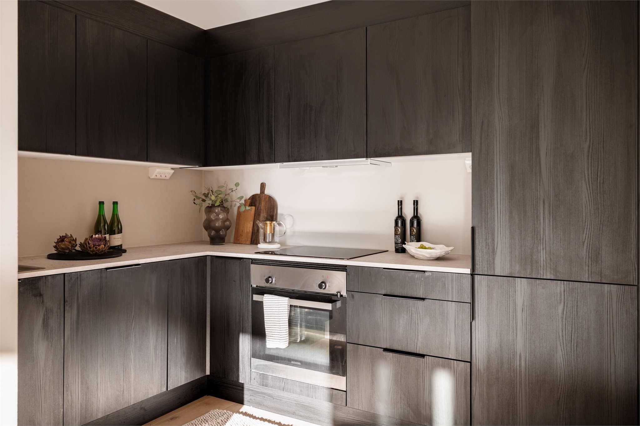 Kjøkkenet har en moderne HTH-innredning fra 2023 med glatte fronter og laminatbenkeplate.