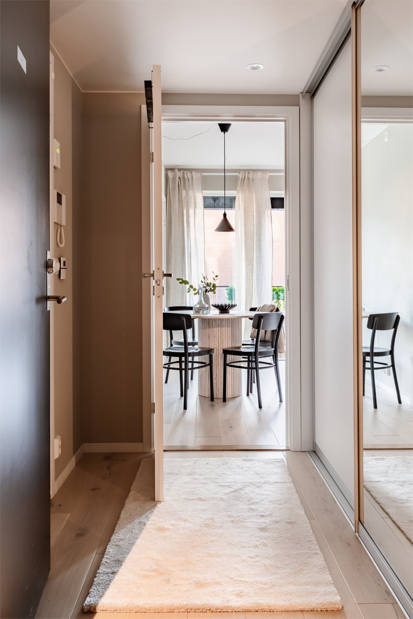 Lys entré med plassbygd garderobe med skyvedører, perfekt for oppbevaring av sko og yttertøy.