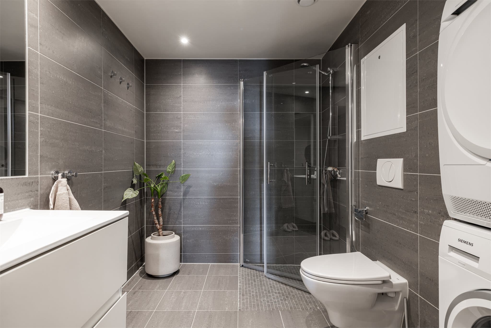 Lekkert baderom med opplegg for vaskemaskin og plass til tørketrommel.