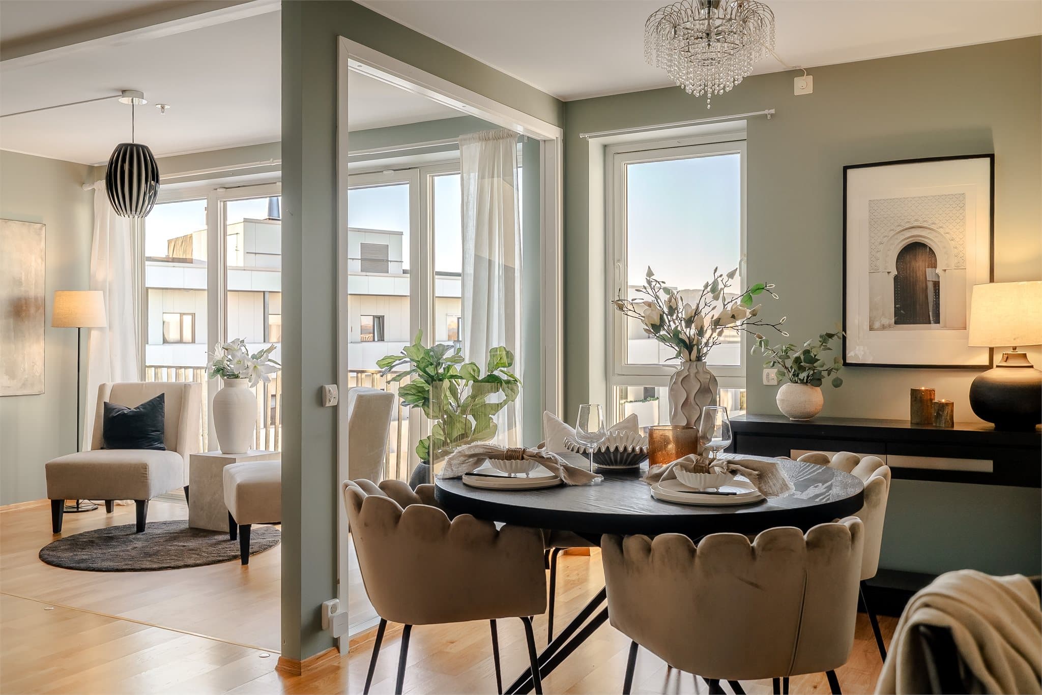 En lun spisestue med store vindusflater som slipper inn rikelig med lys.