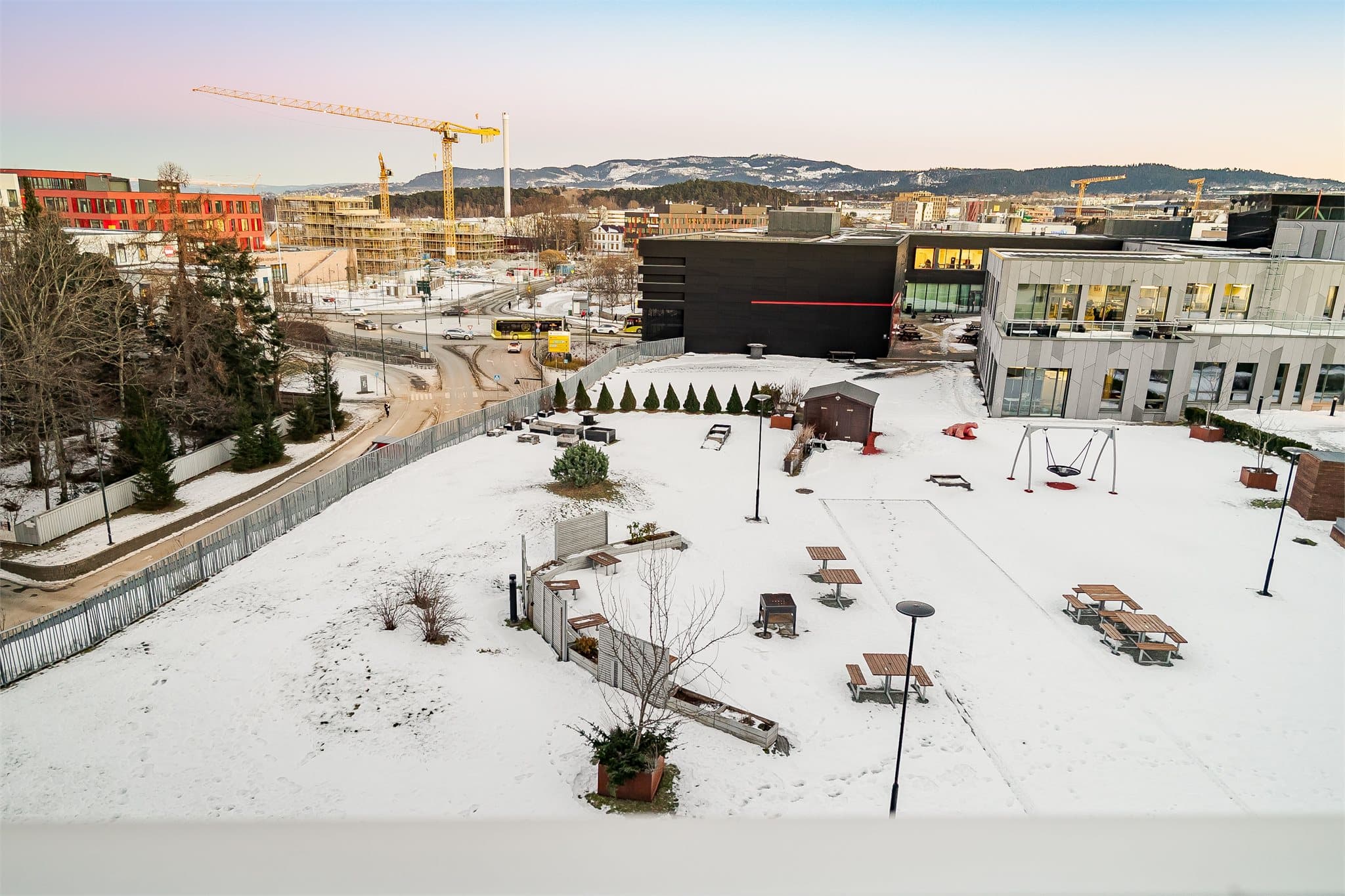Felles uteområde med sitteplasser og grønne soner, pent opparbeidet og skjermet.