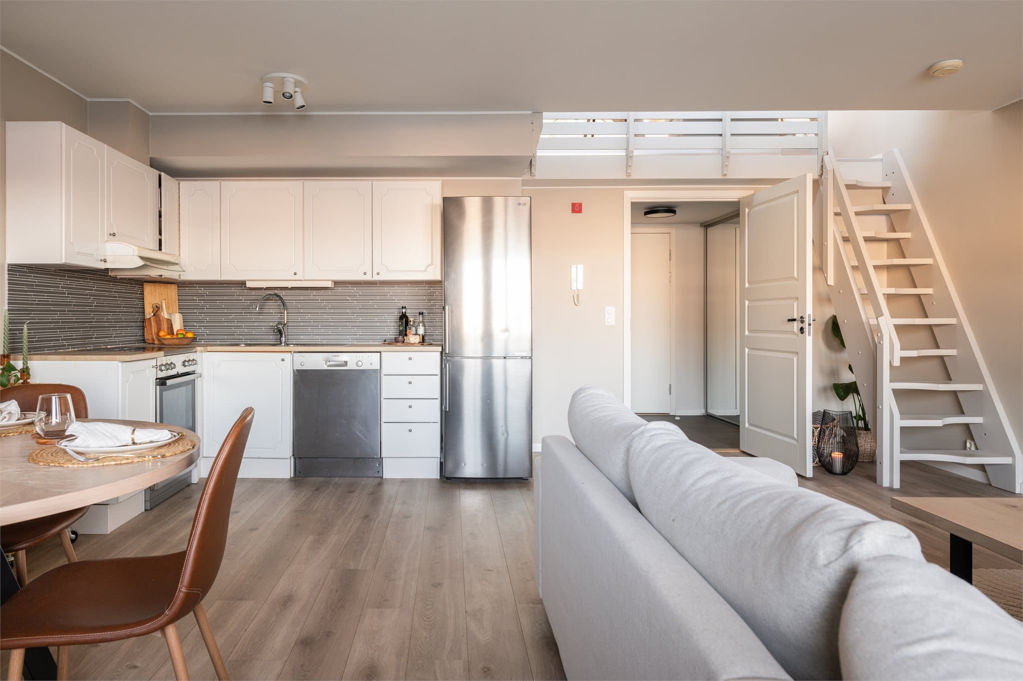 Kjøkkenet ligger i en åpen løsning mot stuen, og sammen danner de et stort, innbydende allrom for avslappende hverdager og hyggelig, sosiale lag.