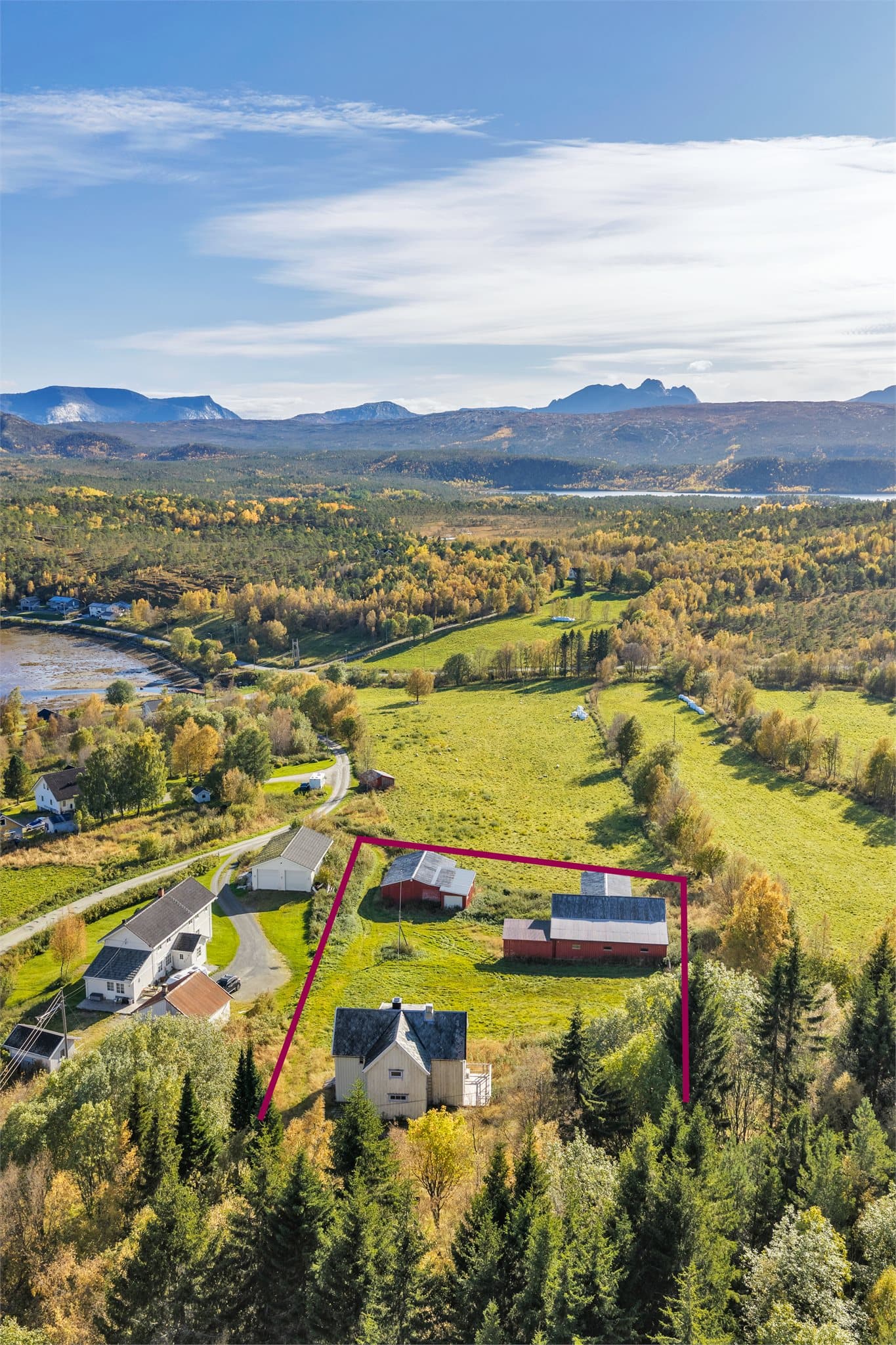 Tomten strekker seg opp mot skogkanten og har utsikt mot fjellene i sør.