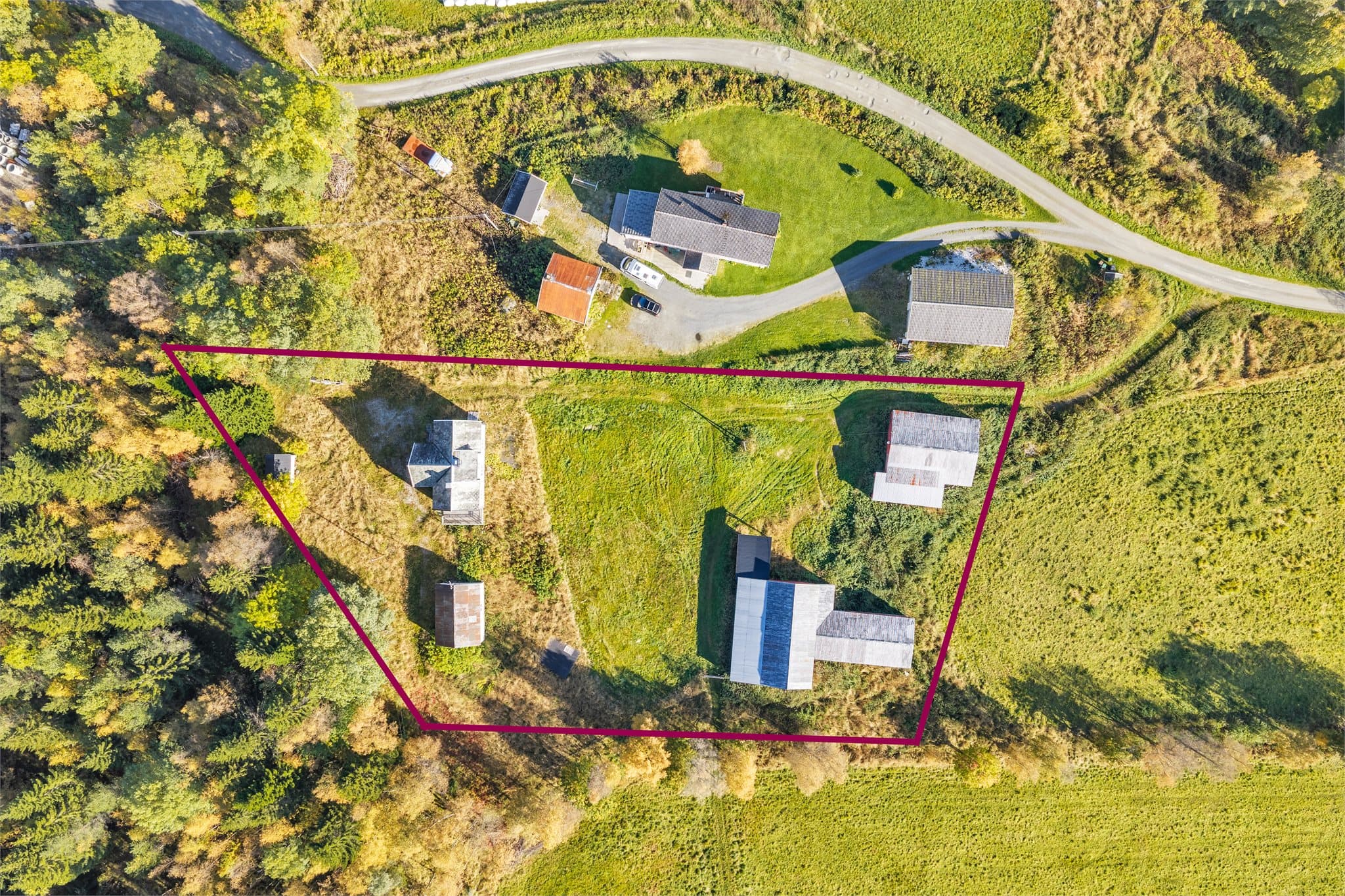 Eiertomt på over fire mål med tun, beitemark og spredte uthusbygninger.