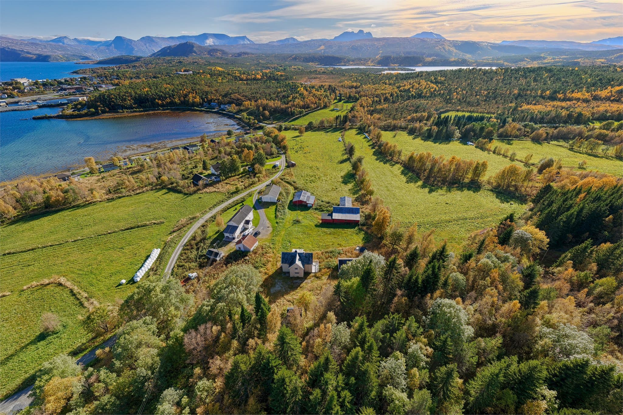 Utsyn over Dragsbukta med sjøen, skogen og fjellformasjonene i horisonten.