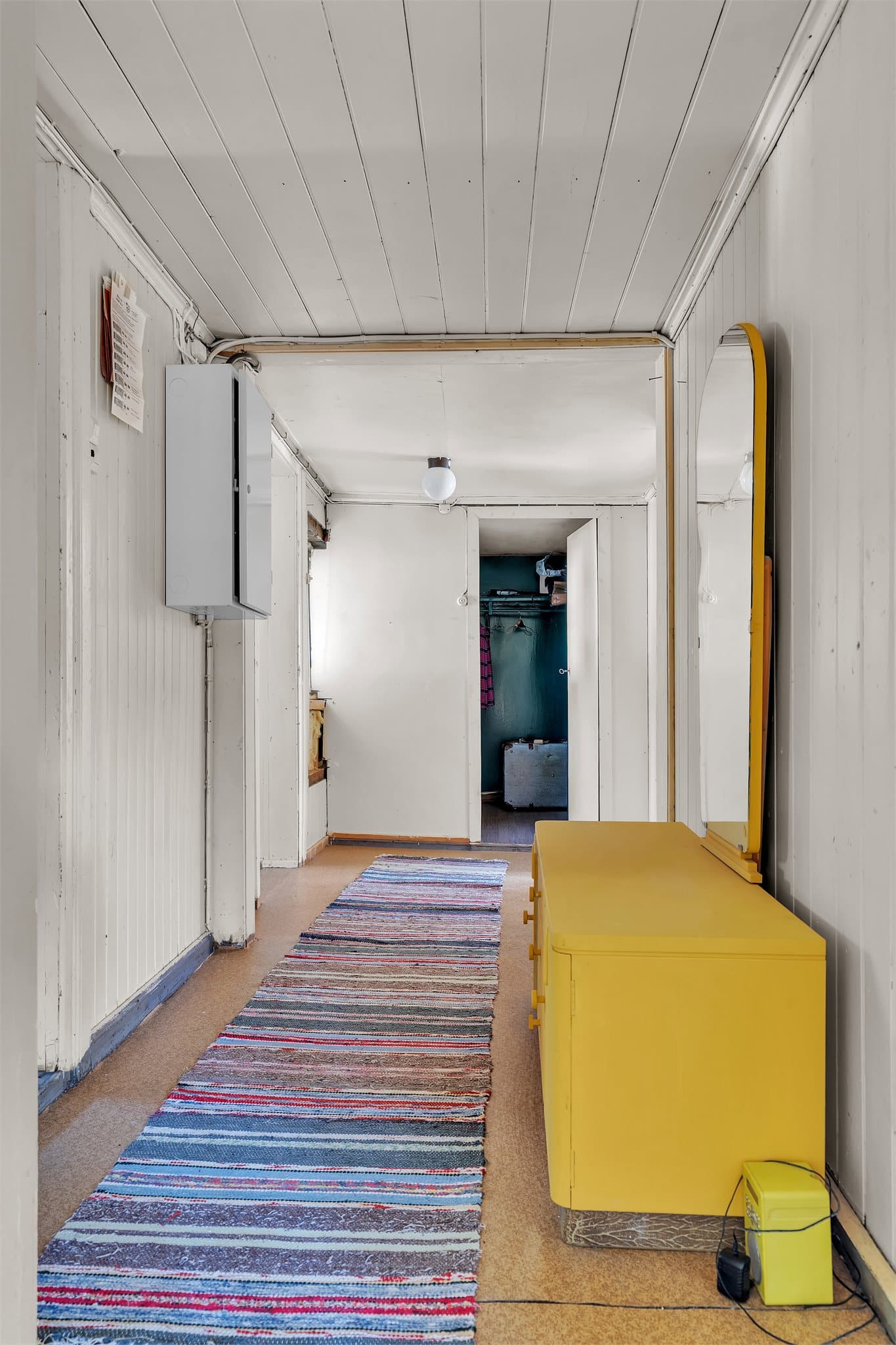 Gangen leder videre inn til boden i loftsetasjen og har sikringsskap med automatsikringer.