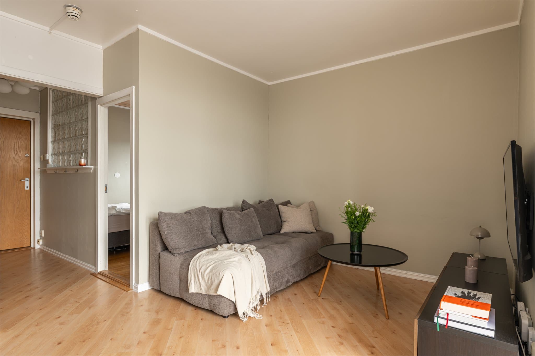 Stuen er lys og innbydende, med en praktisk og lettmøblert planløsning. Beige, malte overflater i hele sonen harmonerer fint med det lyse gulvet og skaper en lun og tidløs atmosfære.
