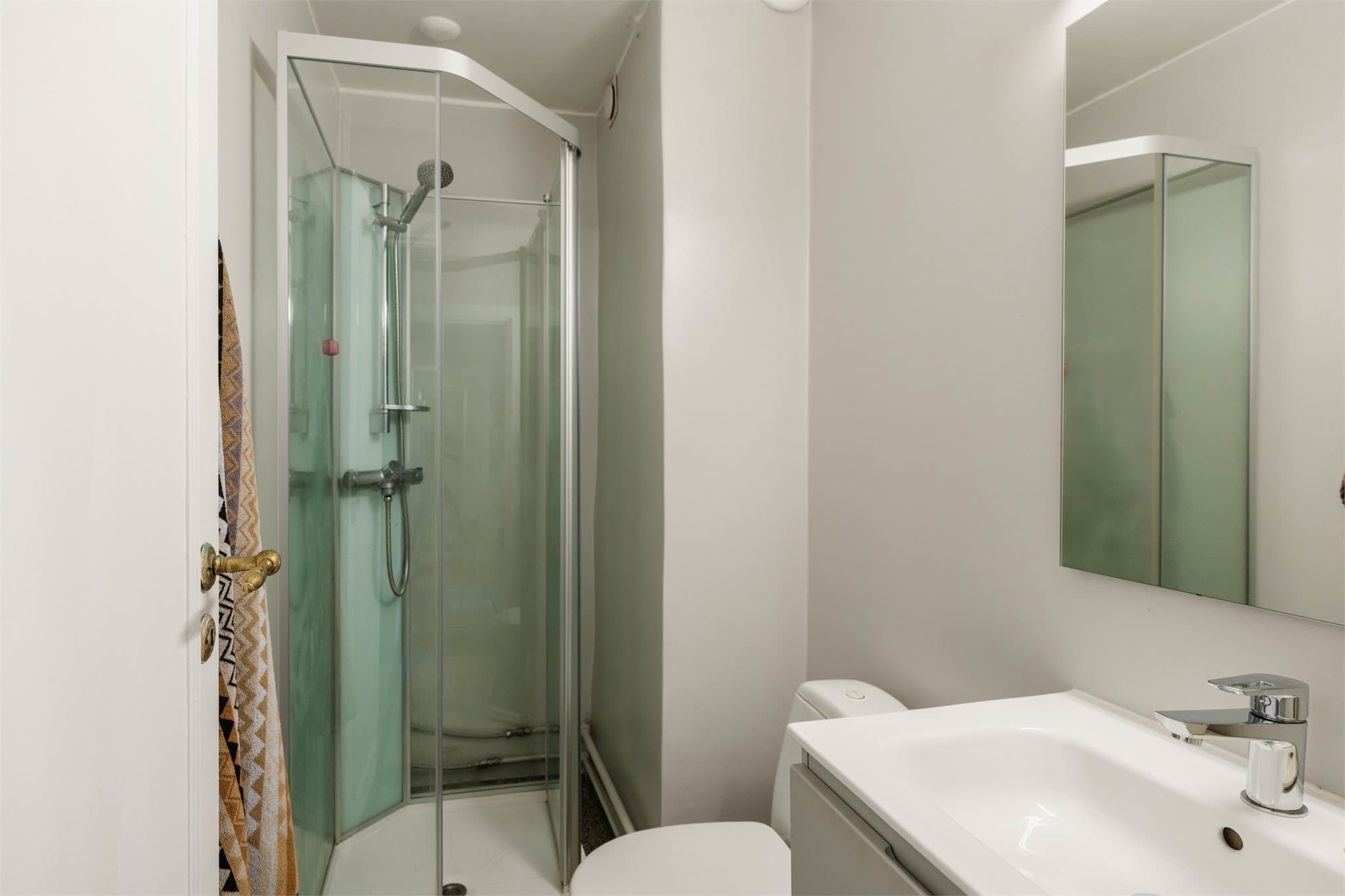 Badet er innredet med vegghengt servantinnredning med skuffer og ovenpåliggende servant med ett-greps armatur.
