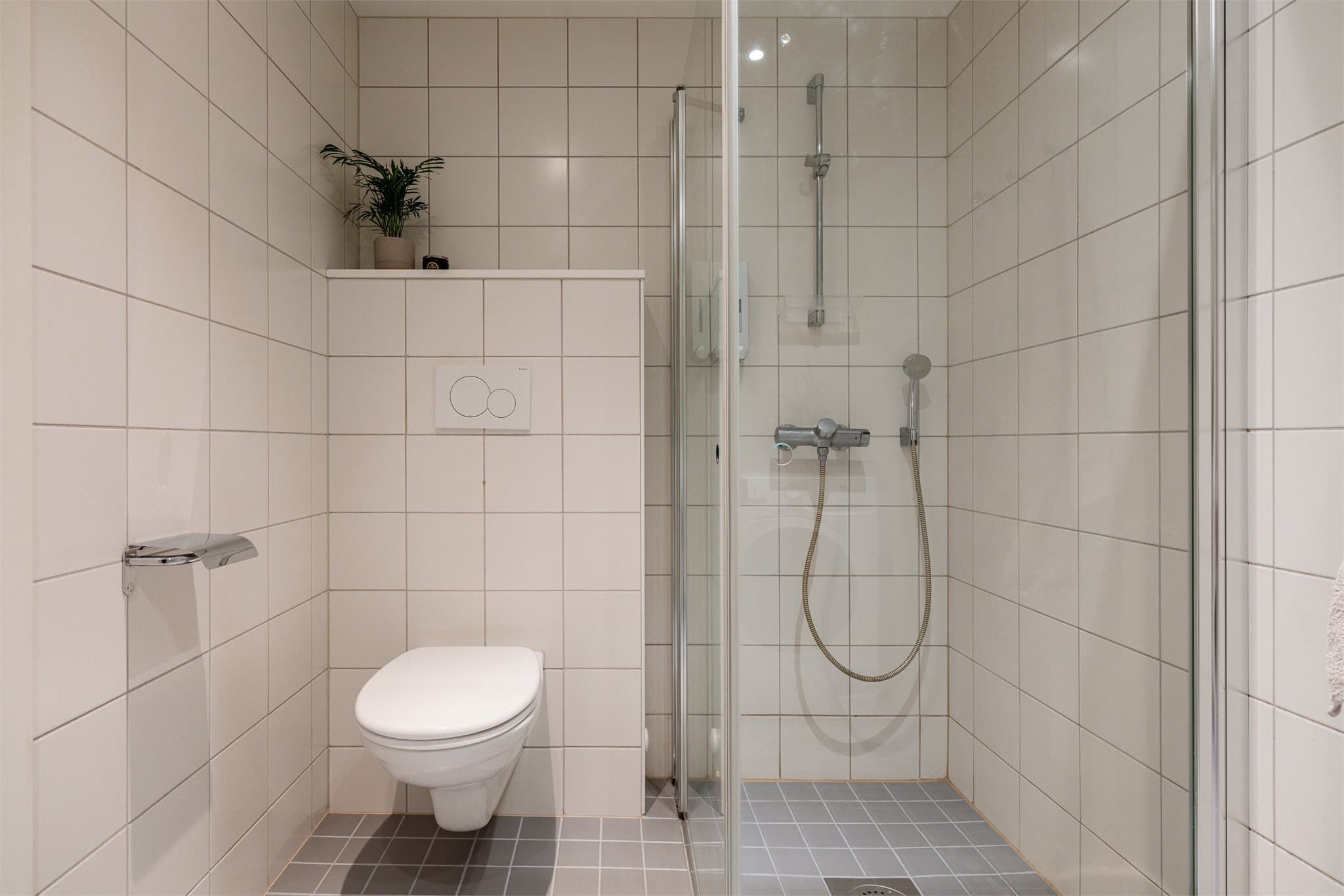 Badet er utstyrt med vegghengt toalett, downlights i himling og har praktisk opplegg for vaskemaskin - en effektiv utnyttelse av plassen.