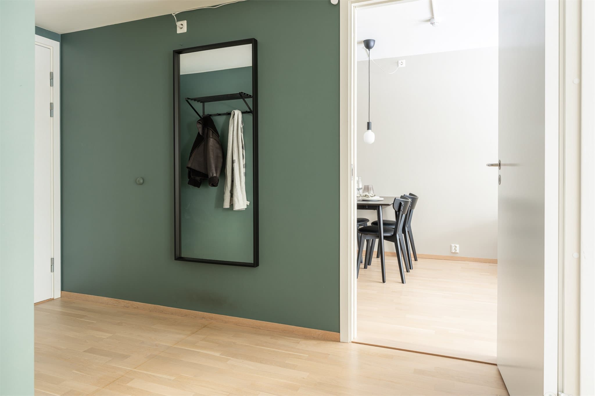 Fra kjøkkenet er det utgang til den smakfulle entréen som fører deg videre til leilighetens øvrige rom.