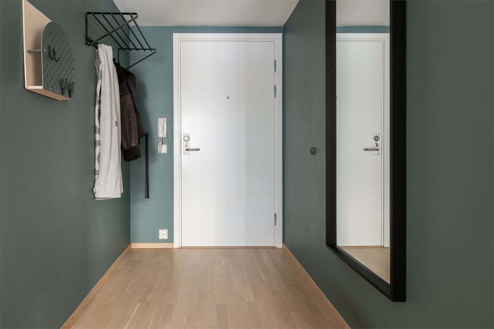 Velkommen inn! Entreen gir et fantastisk førsteinntrykk med nyslipte gulv og en dyp, moderne farge på veggene som skaper en lun velkomst.
