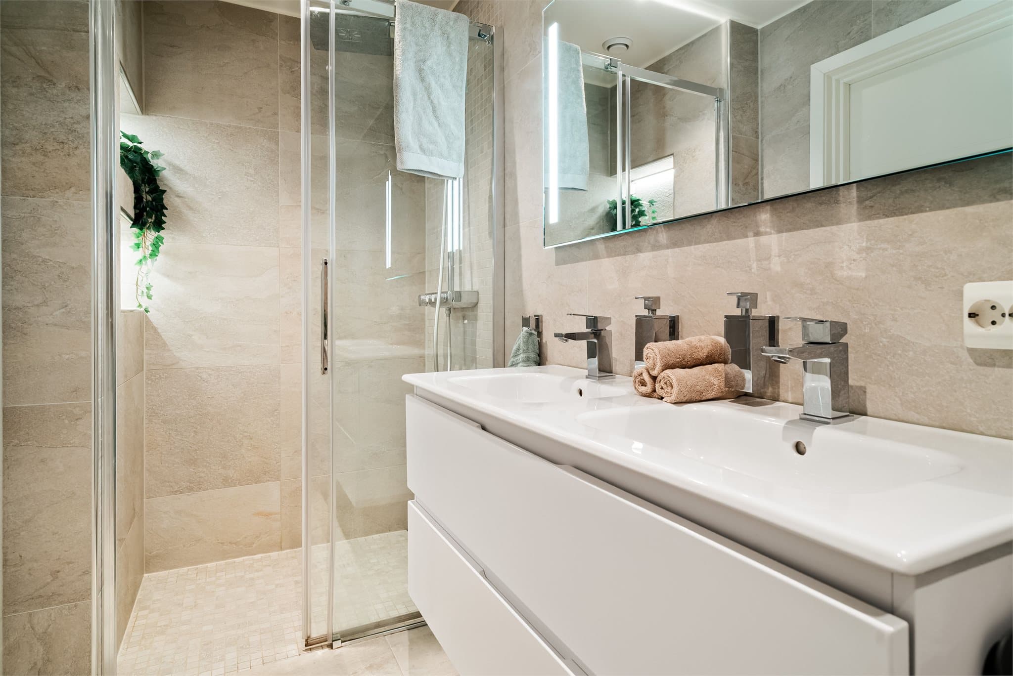 Badet ble renovert i 2020 med stilrene fliser, dobbel servant og en romslig dusjnisje.