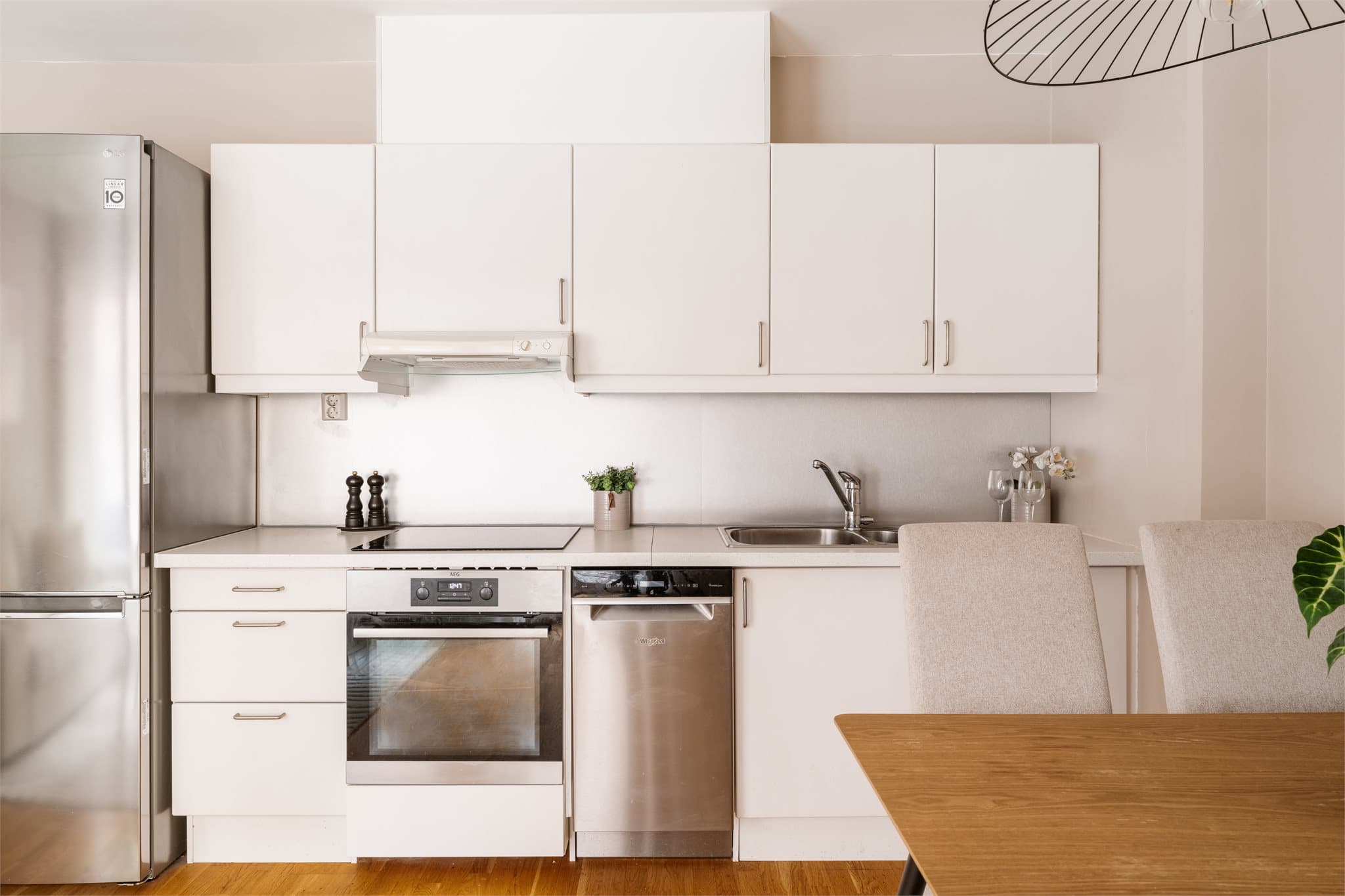 Moderne kjøkkeninnredning med glatte fronter og laminat benkeplate.