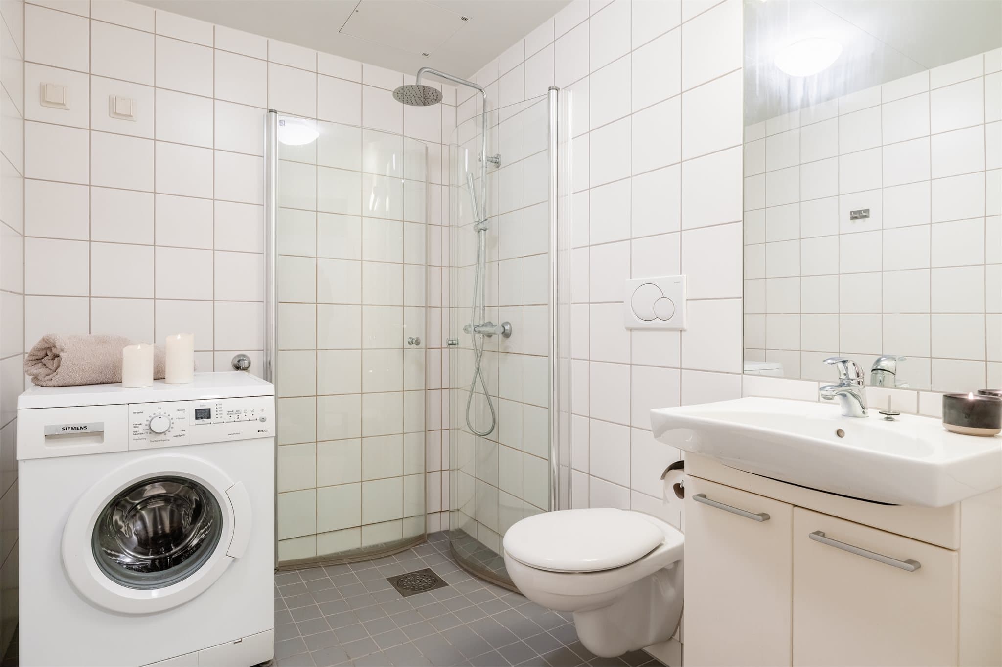 Flislagt bad med elektrisk gulvvarme og opplegg for vaskemaskin.