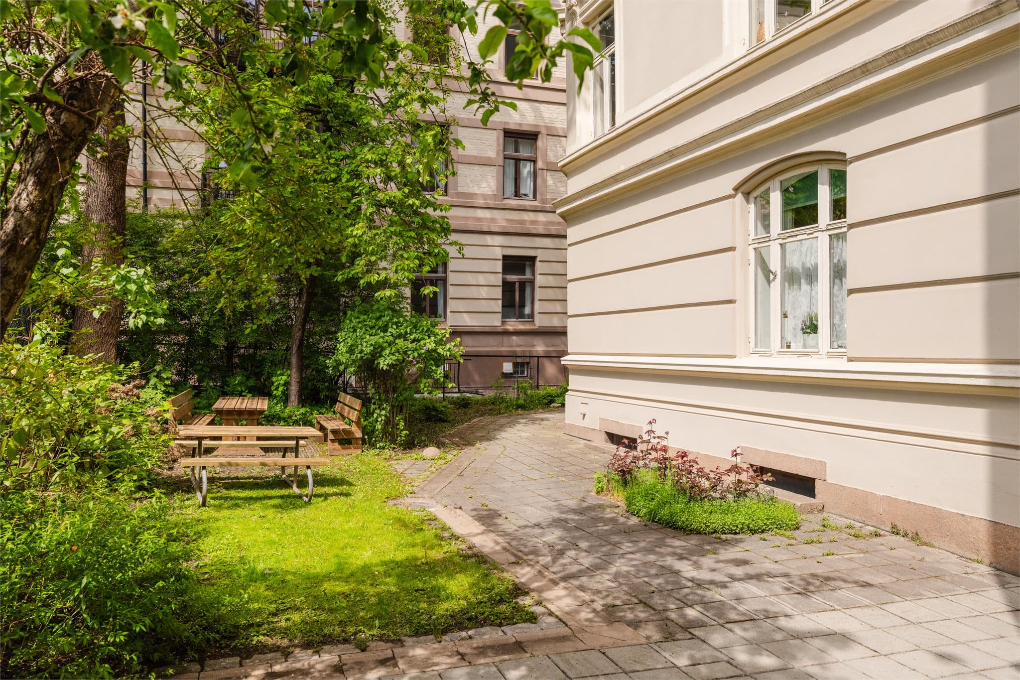 Hyggelig bakgård med sittegrupper og grønne omgivelser om sommeren!