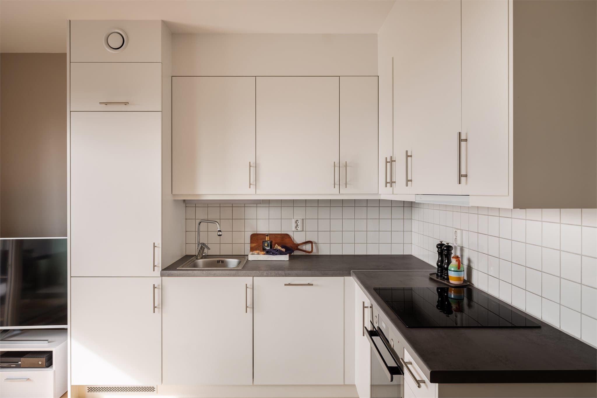 Kjøkkeninnredning fra 2021 med hvite, slette fronter og laminert benkeplate.