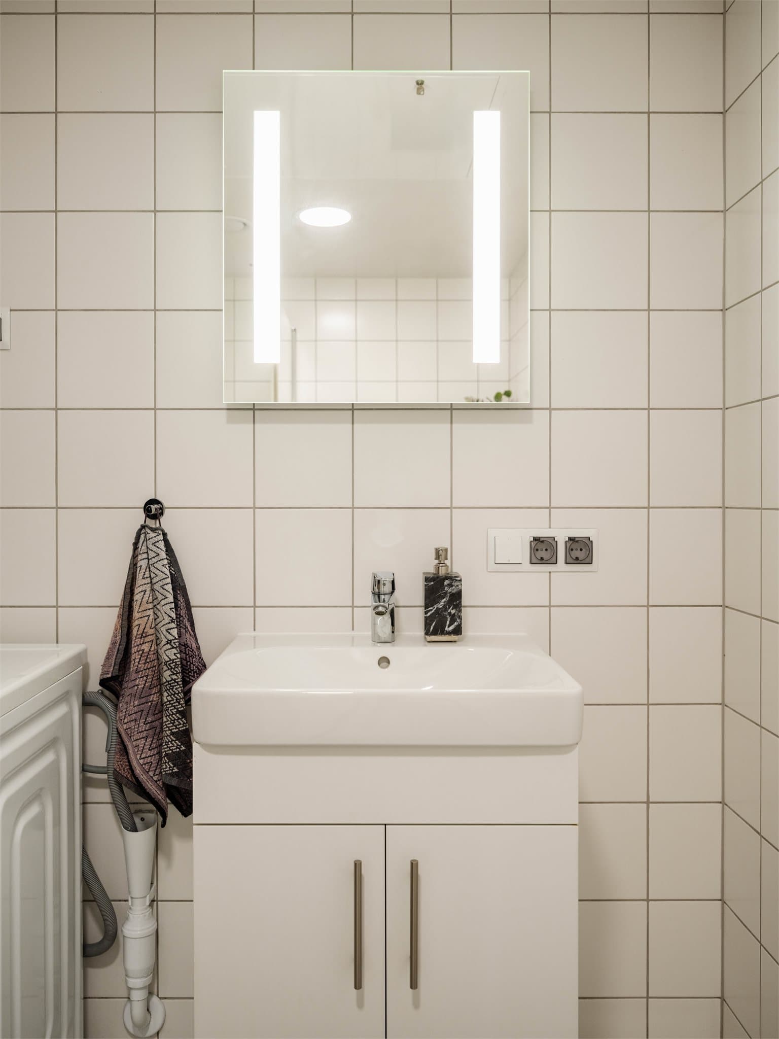 Badet er utstyrt med dusjnisje med innfellbare glassdører og opplegg for vaskemaskin.