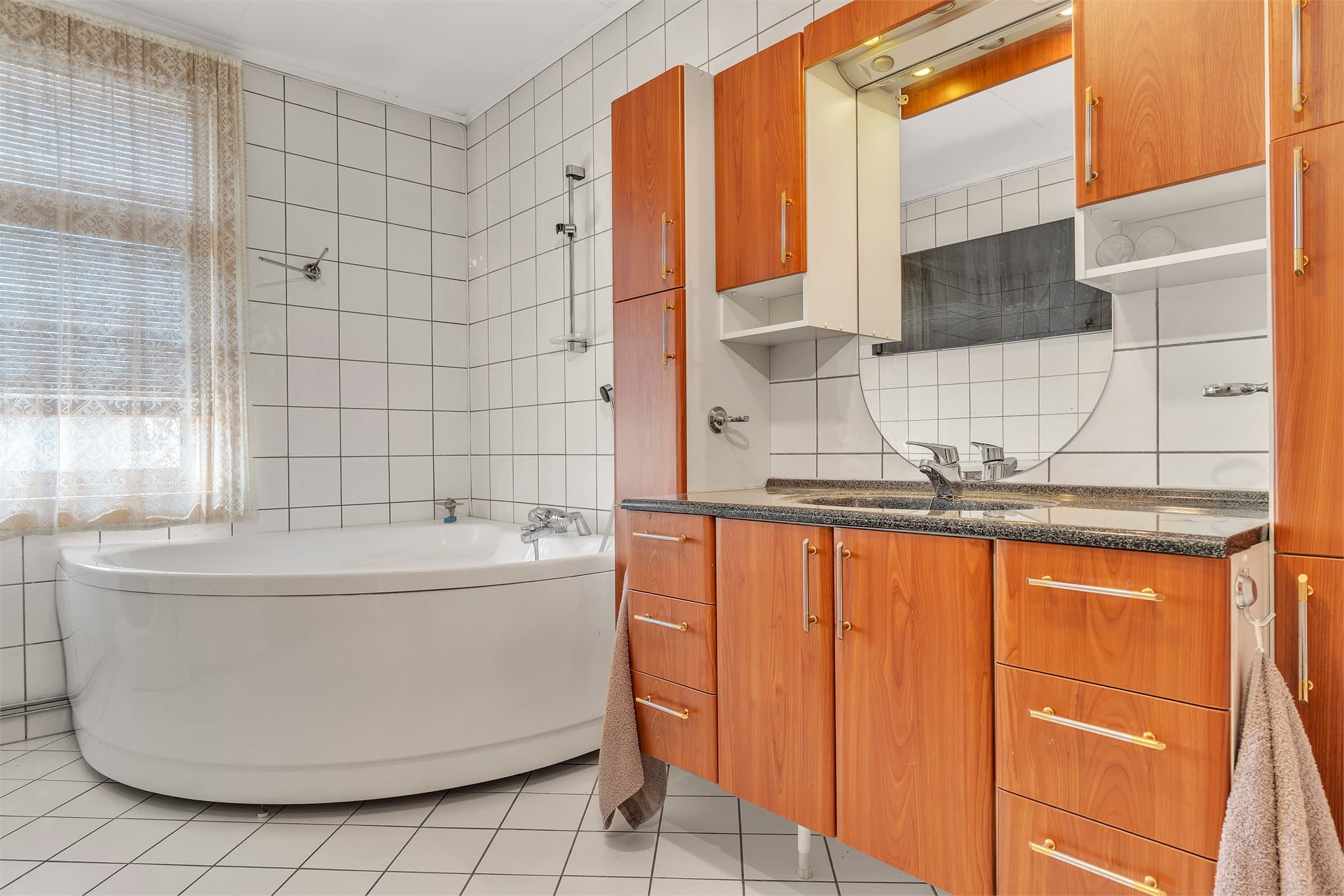 Stort, flislagt bad med både badekar og dusjkabinett.
