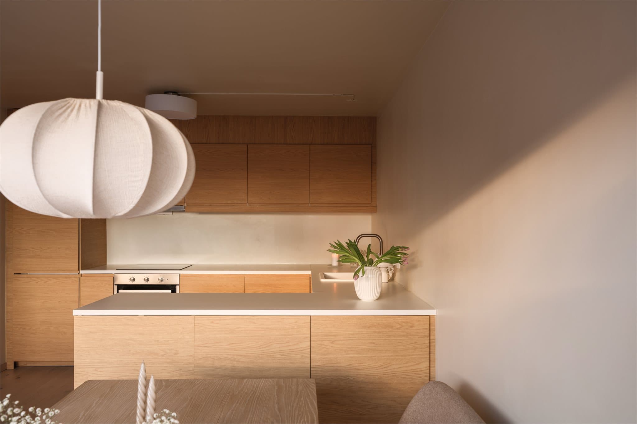 Kjøkkenets U-form fungerer som en naturlig romdeler og gir ekstra arbeidsflate.