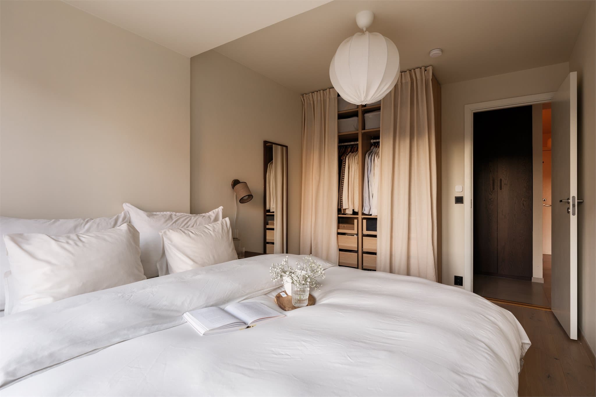 Rommet har også en åpen garderobe som gir praktisk og lekker oppbevaringsplass.