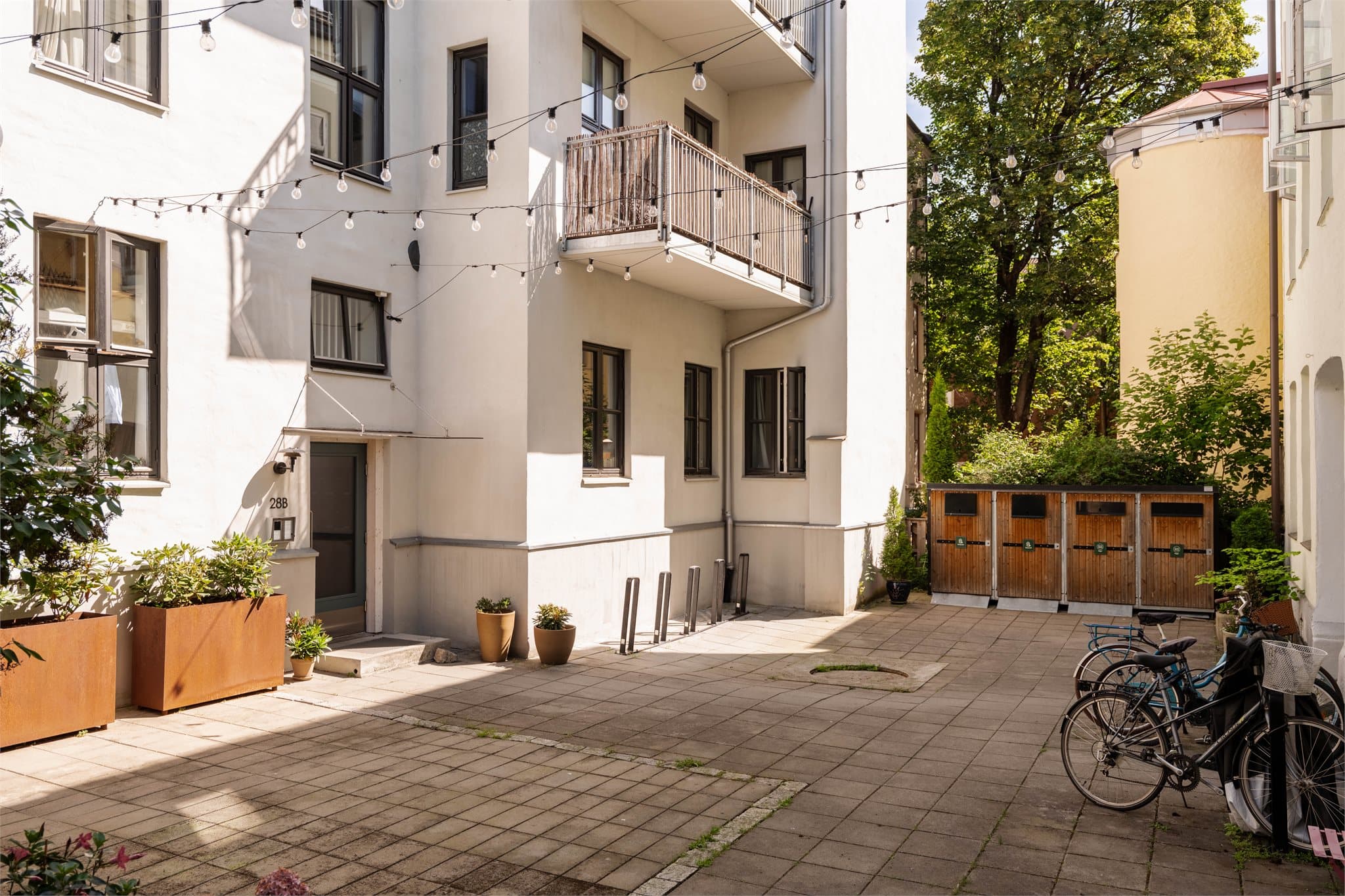 Bygården ligger tilbaketrukket fra gaten, med et pent opparbeidet inngangsparti.