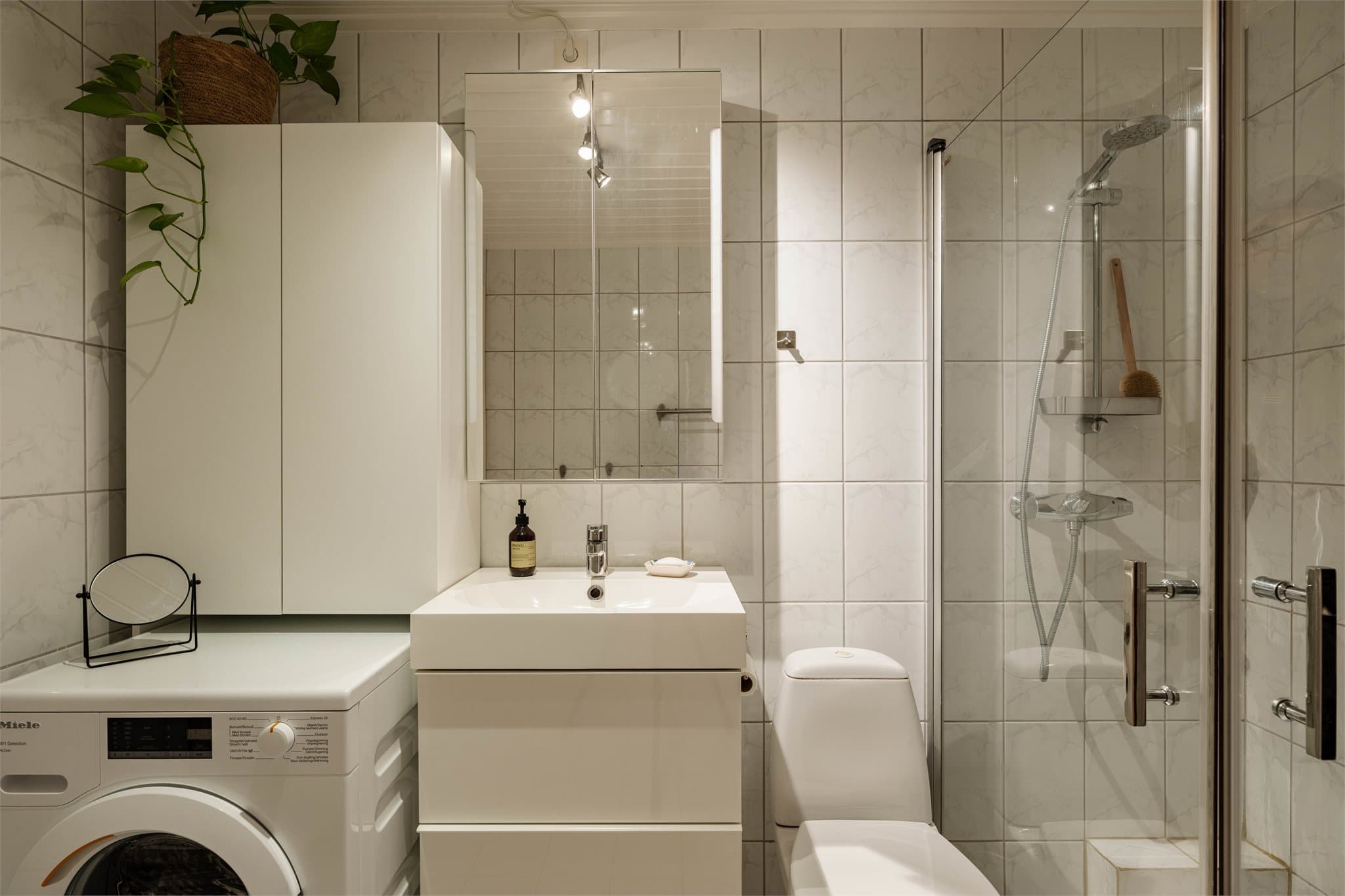 Badet har opplegg for vaskemaskin og innredning med nedfelt servant.