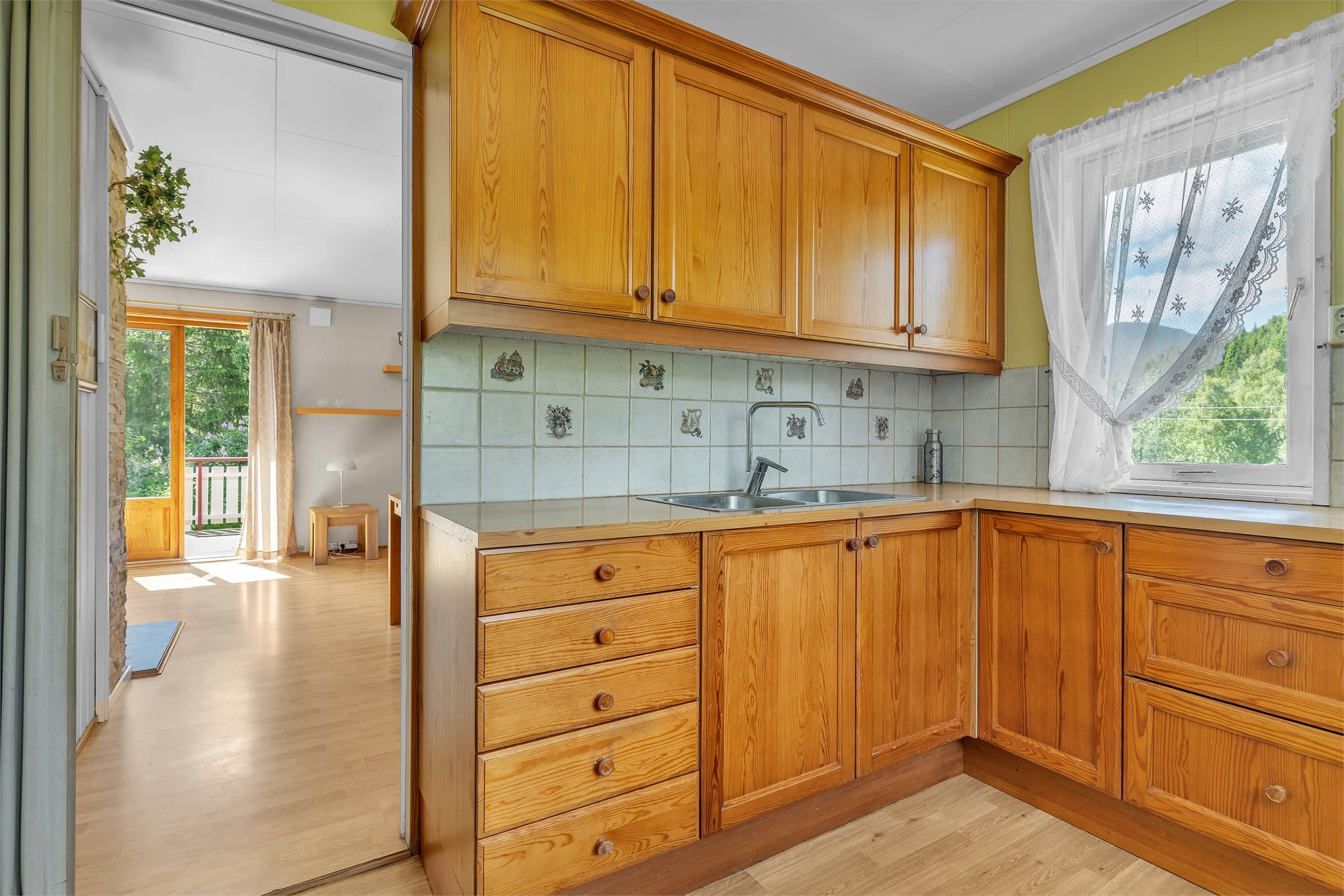Kjøkkeninnredning i furu med speilfronter og benkeplate i Respatex.
