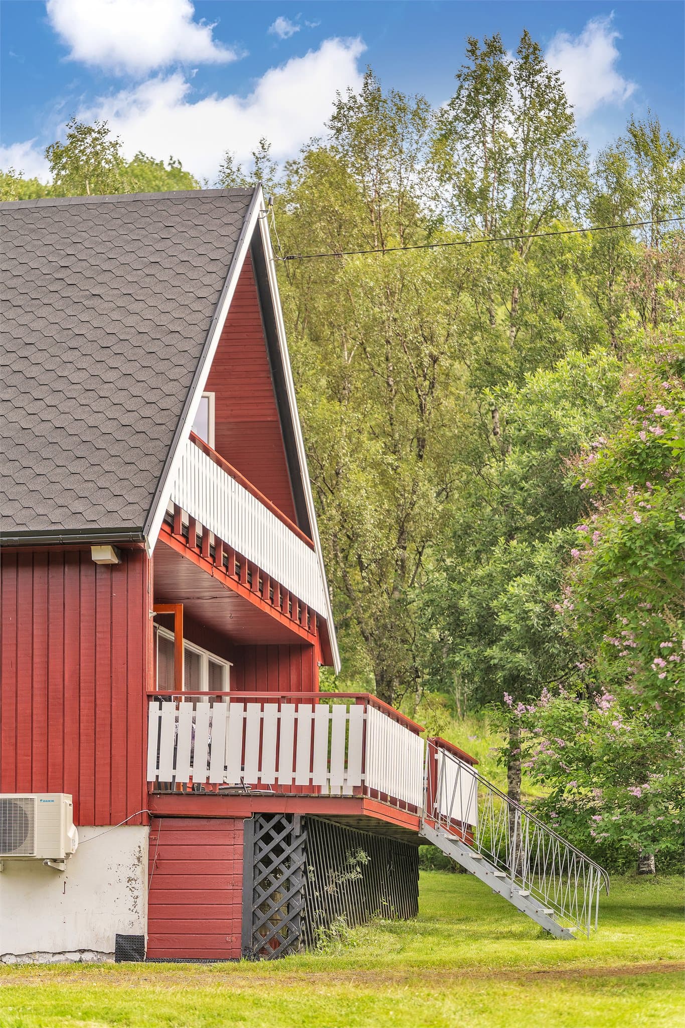 Utvendig metalltrapp med trinn av strekkmetall gir tilgang til verandaen.