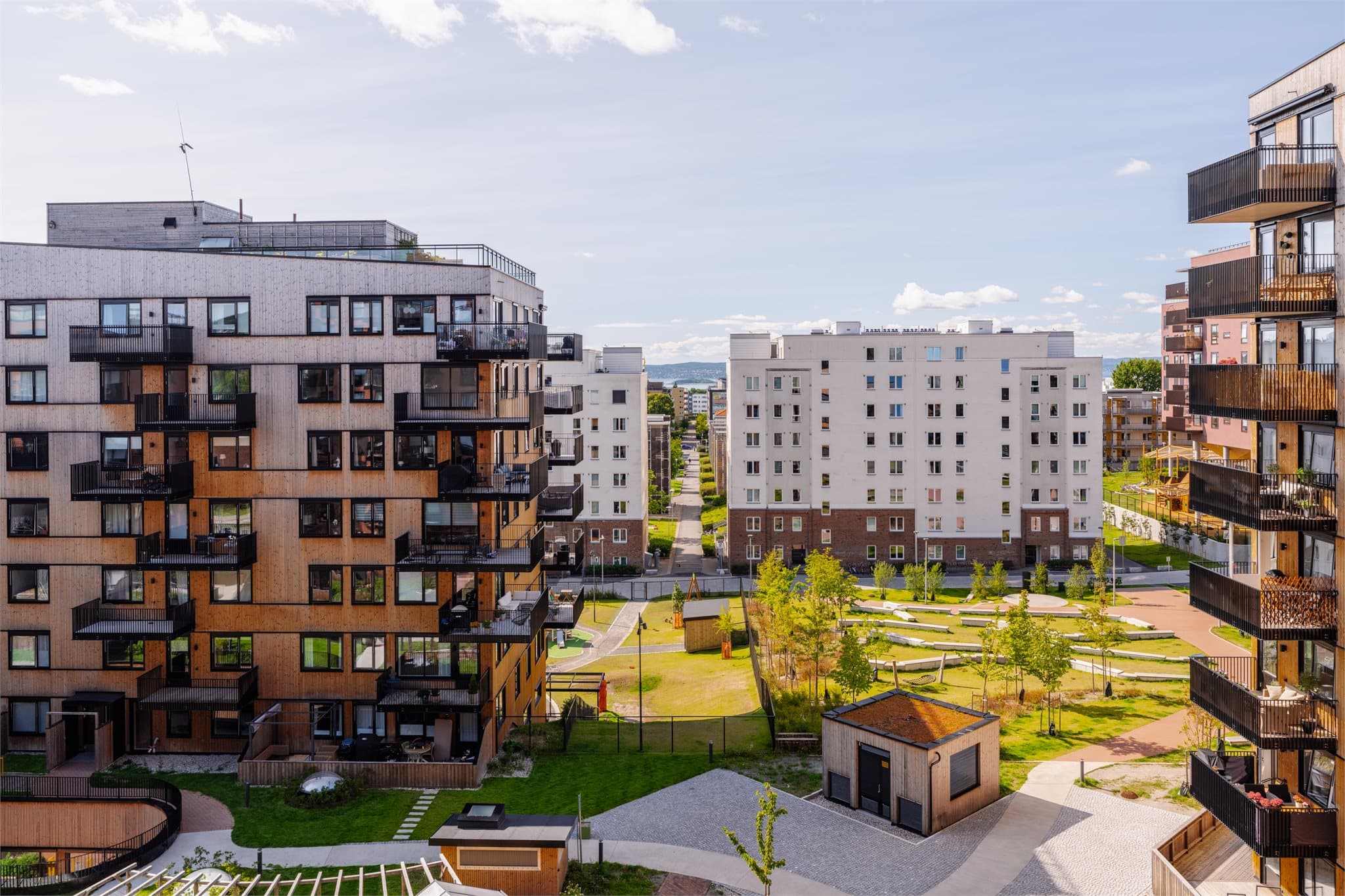 Utsikt balkong. Rett nedenfor finner du det som er en av Lørens flotteste gårdsrom nå med drivhus, benkeområder, lekeplasser og tuftepark.