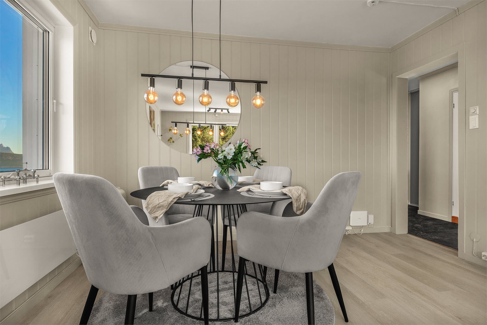 En lys og trivelig spiseplass ved vinduet.