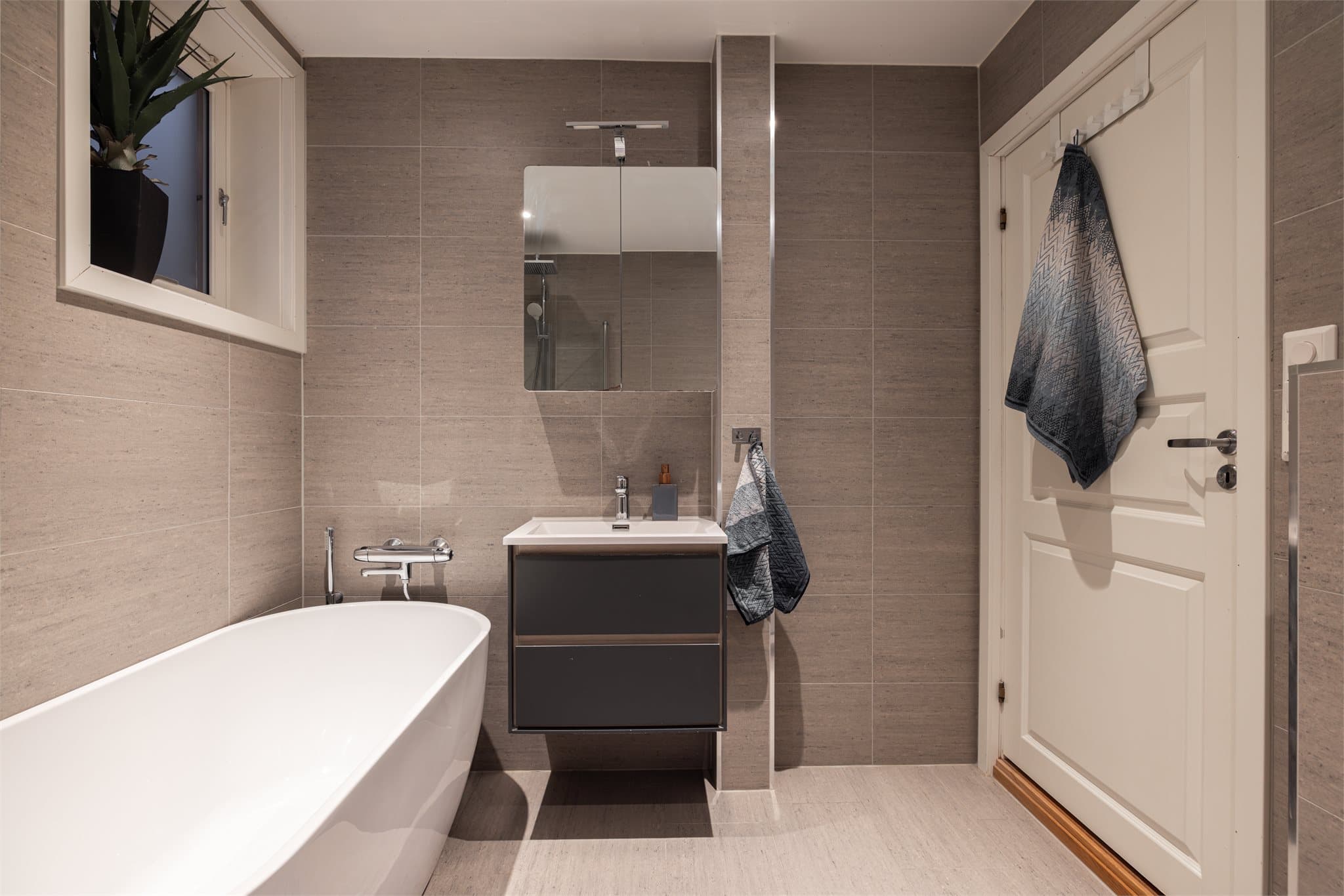 Innredningen består av en servant med skuffer og et speilskap med belysning og stikkontakt.