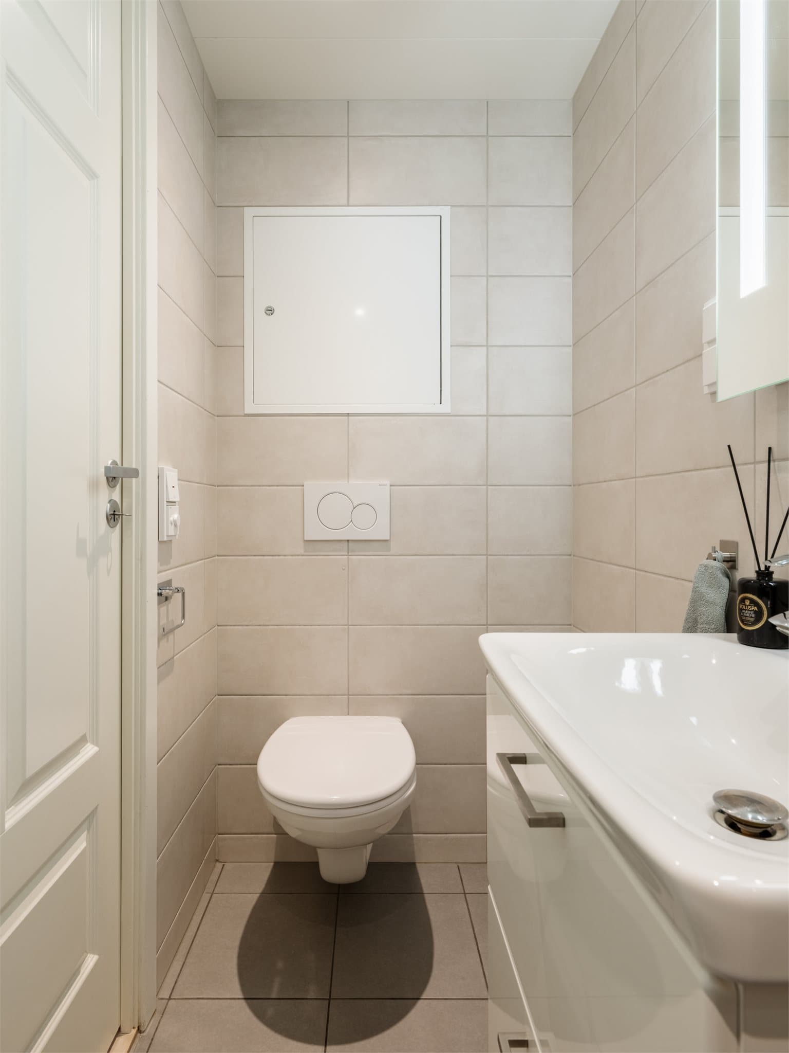Badet er utstyrt med servant med skuffeinnredning samt vegghengt toalett med innebygget sisterne.
