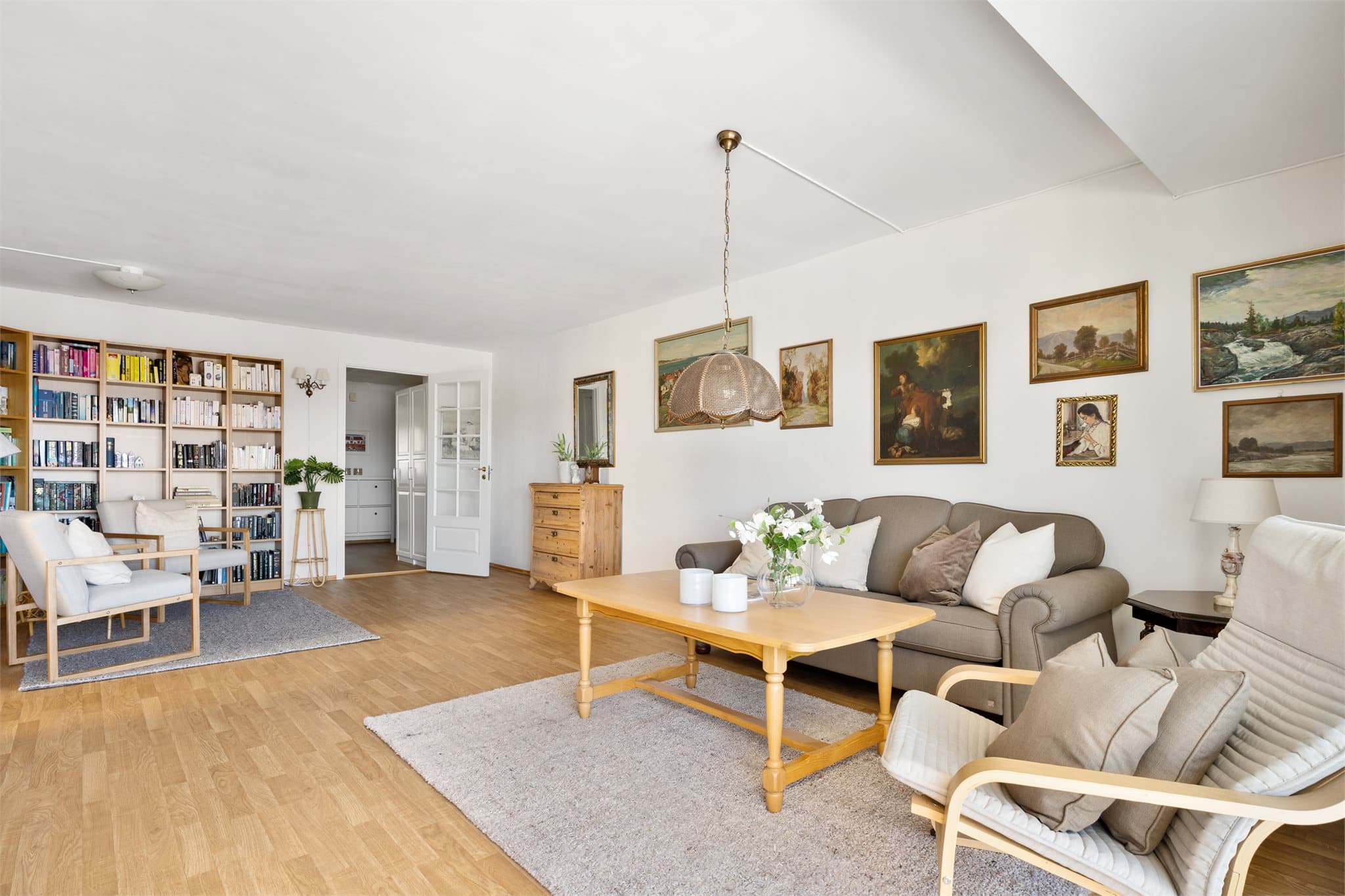 Slå deg løs: Stuen i leiligheten er både romslig og fleksibel, og legger til rette for en rekke møbleringsmuligheter. Med store vindusflater og skyvedør ut til balkongen, slipper dagslyset inn fra flere sider, noe som gir en lys og luftig atmosfære.