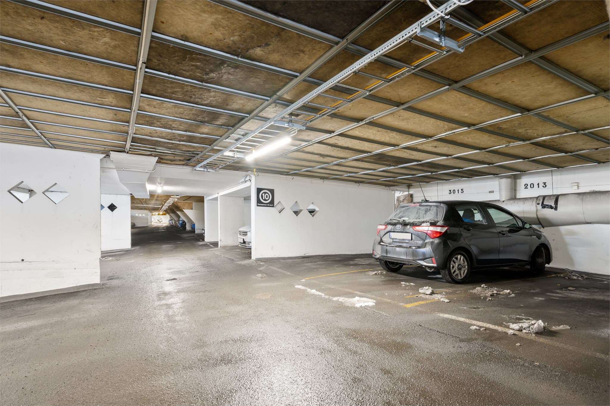 Rett under leiligheten: Til leiligheten følger en praktisk garasjeplass i felles garasjeanlegg under terrasseblokkene, som gir enkel og trygg parkering uansett vær.