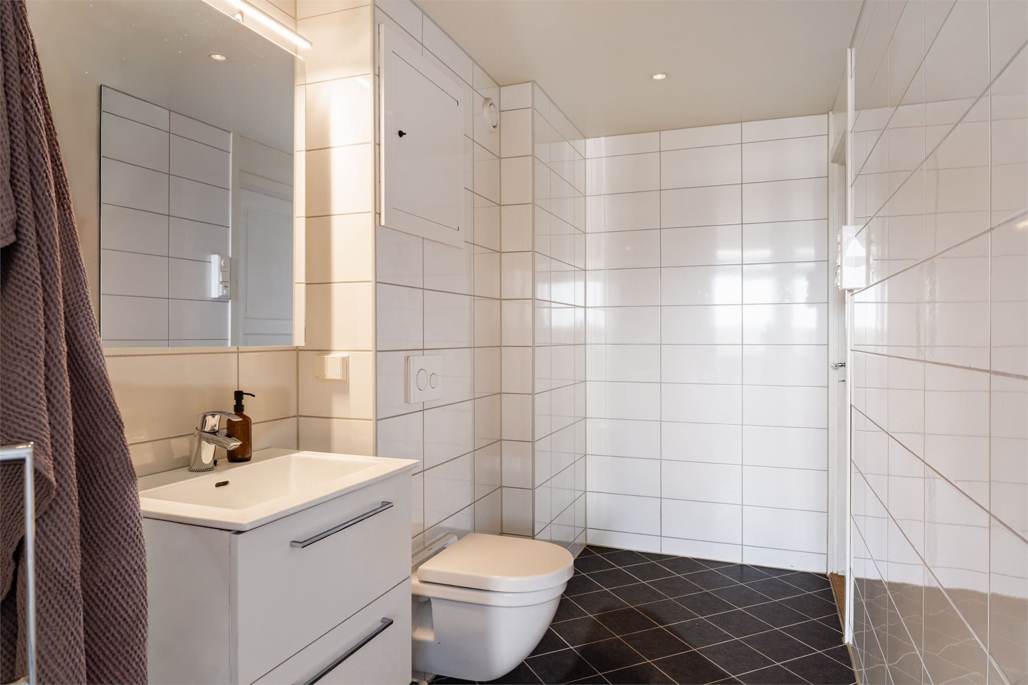 Badet har flislagte overflater og varme i gulvet.