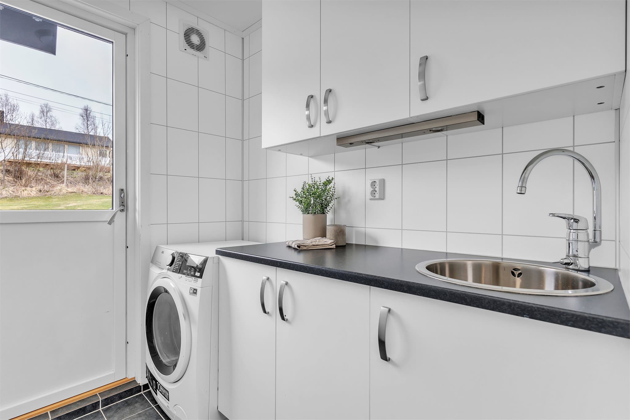 Vaskerom med utgang til terrasse på boligens bakside