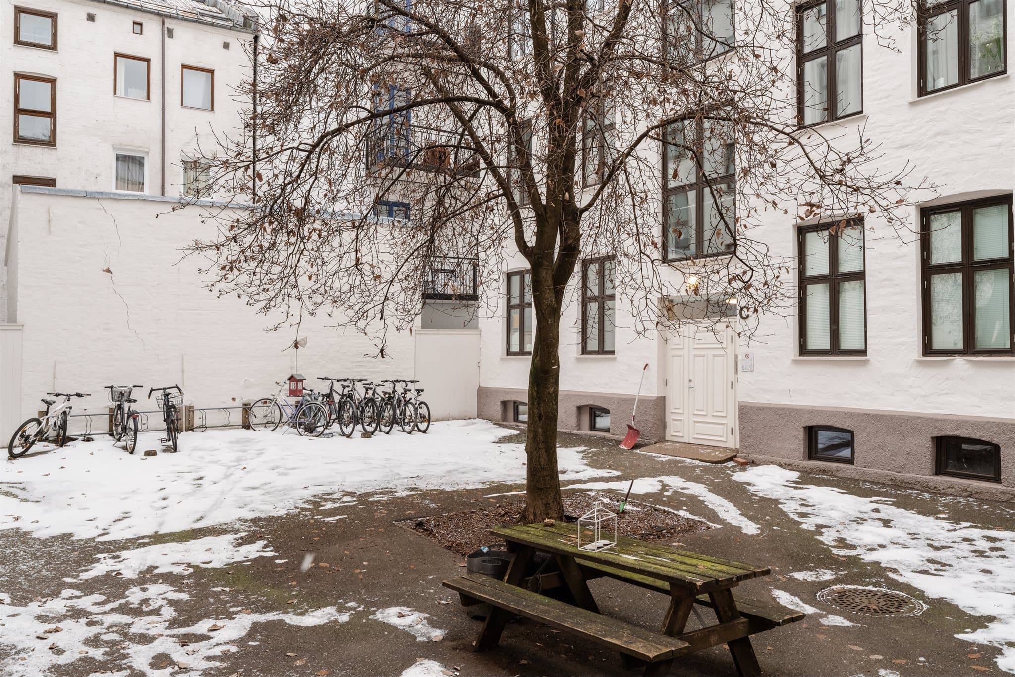 Skjermet bakgård med sittegruppe og sykkelparkering.