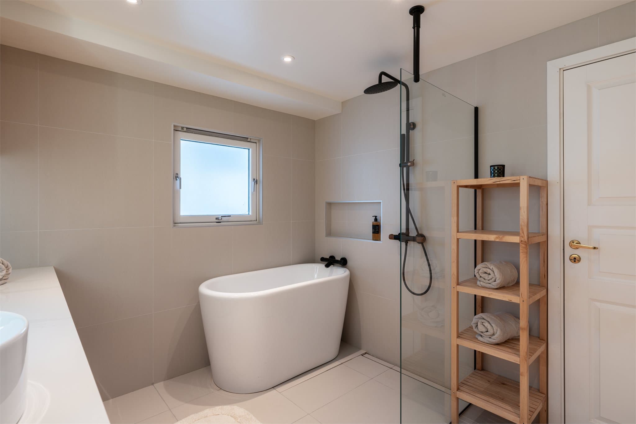 Rommet er helfliset med store 60x60 fliser, og det er elektriske varmekabler i gulvet.