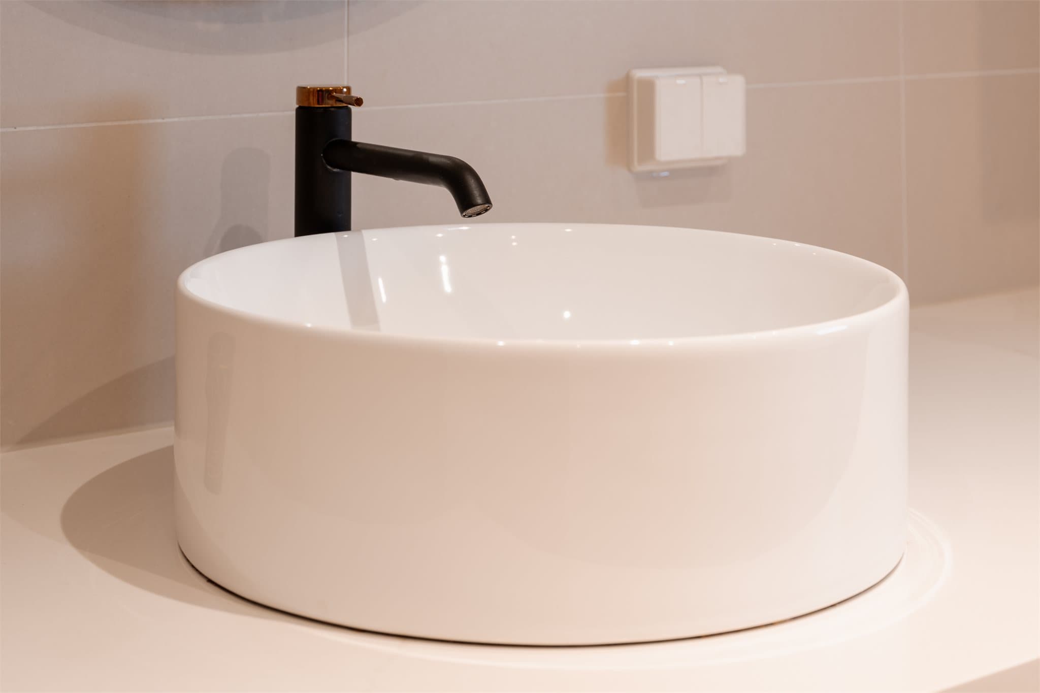 Detaljer som den runde servanten og ettgreps kranen understreker den gjennomførte stilen.