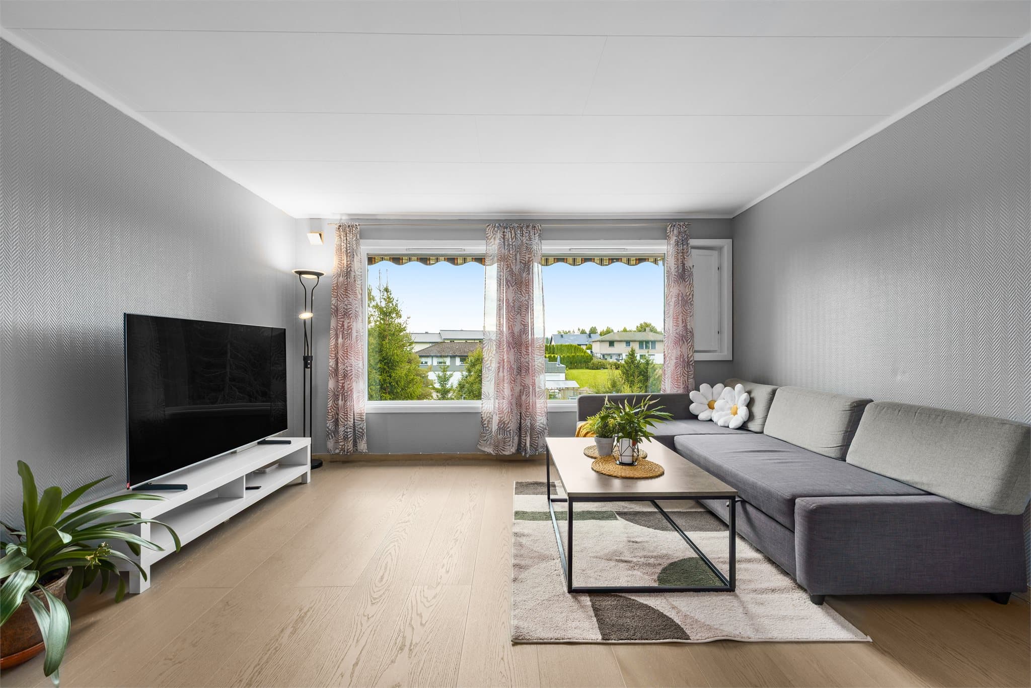Lys stue med gode møbleringsmuligheter og plass til både sofagruppe og spisebord.