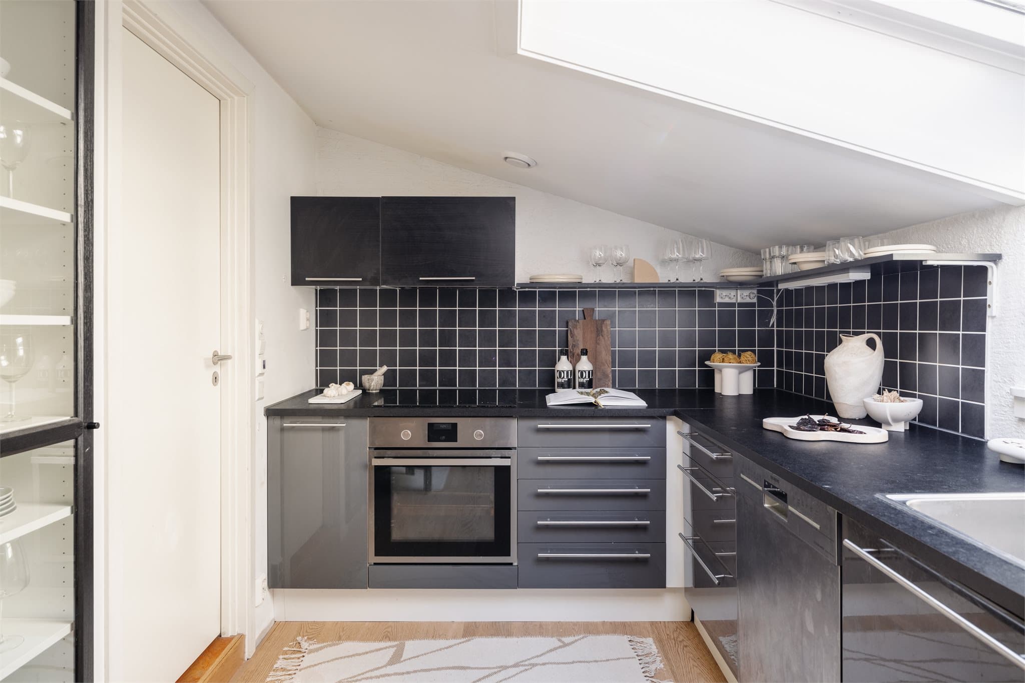 IKEA-innredning fra 2018 med glatte fronter, mørke fliser over benk og benkeplate i laminat.