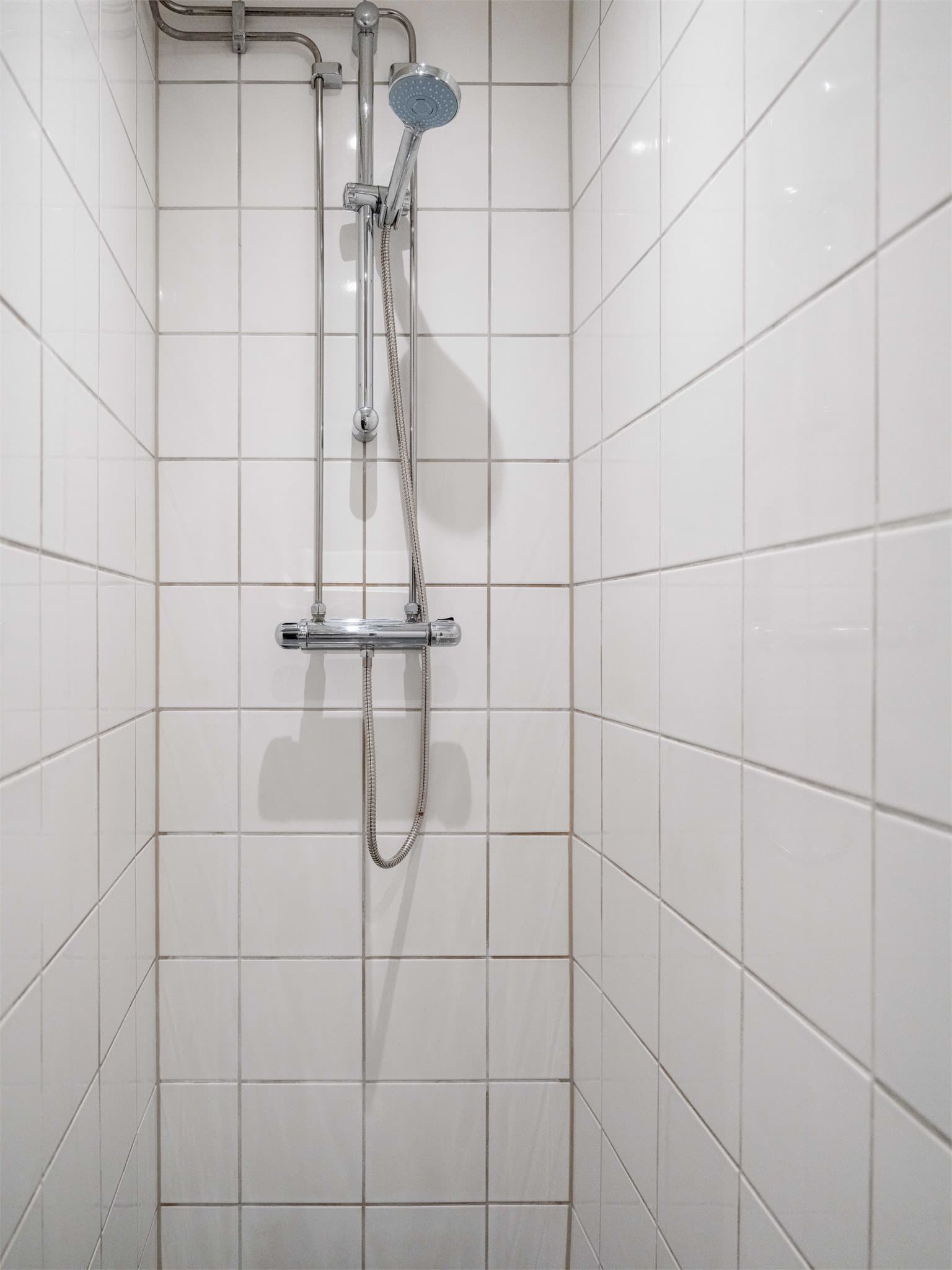 Praktisk dusj på gulv og opplegg for vaskemaskin gjør badet komplett.