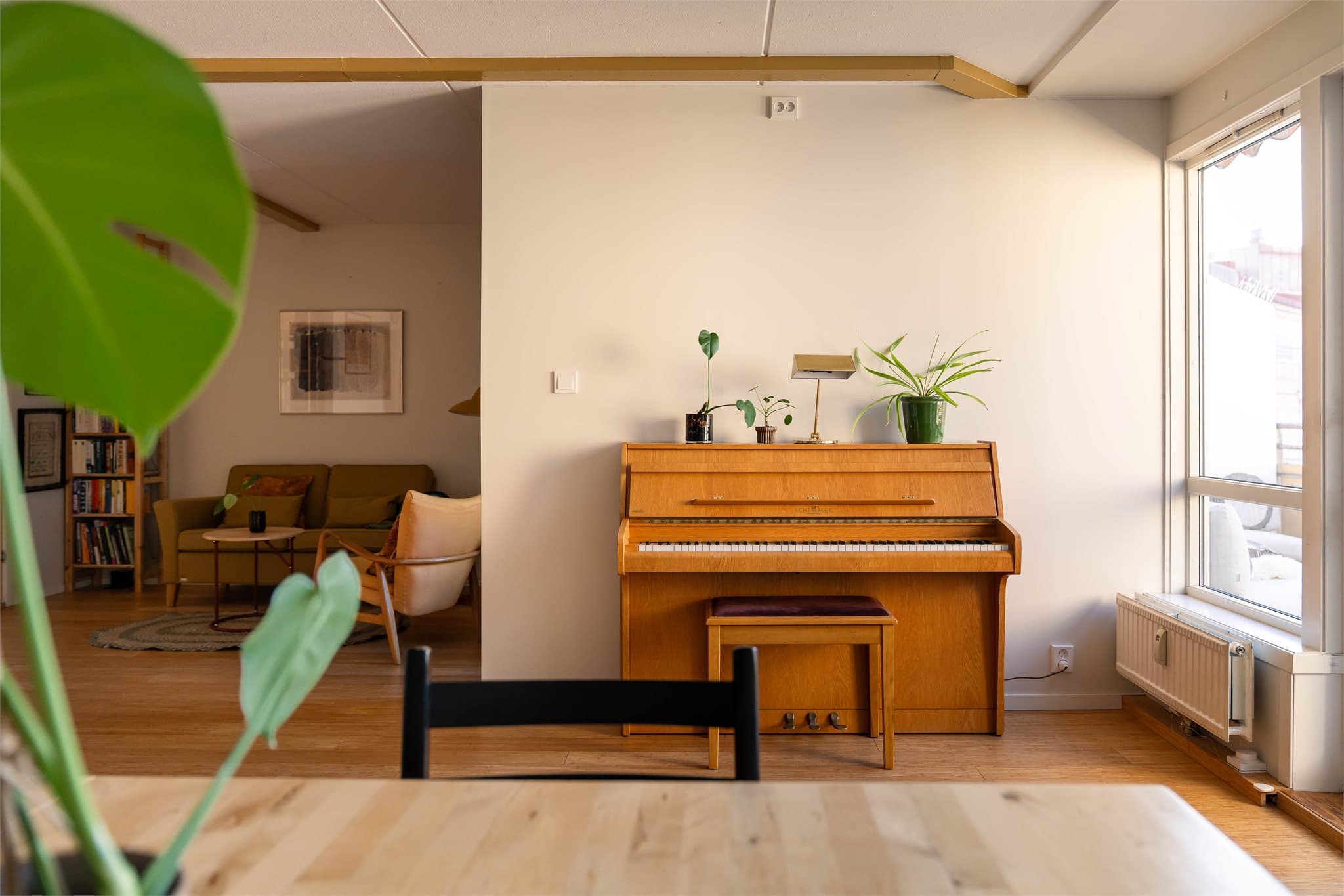 Stuen har plass til både sofagruppe og spisebord, og de store vindusflatene bidrar til fint lysinnslipp.