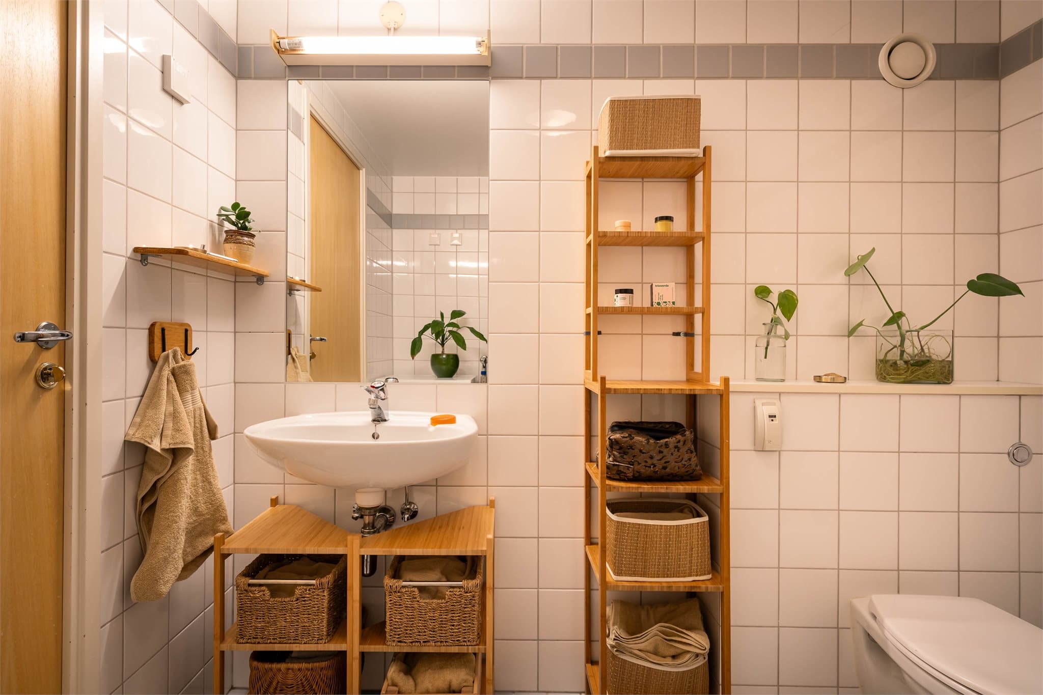 Rommet er innredet med servant, vegghengt toalett og dusjsone med dusjforheng.