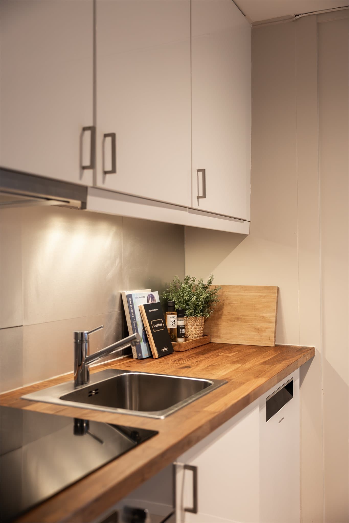 Benkeplaten i heltre gir en varm kontrast til de lyse frontene.