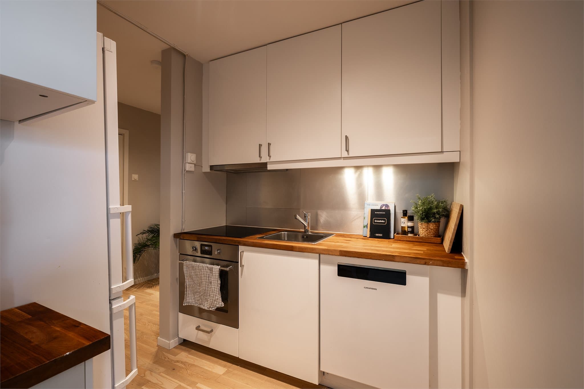 Praktisk Ikea-kjøkken med benkeplate i heltre, integrert komfyr og induksjonstopp.