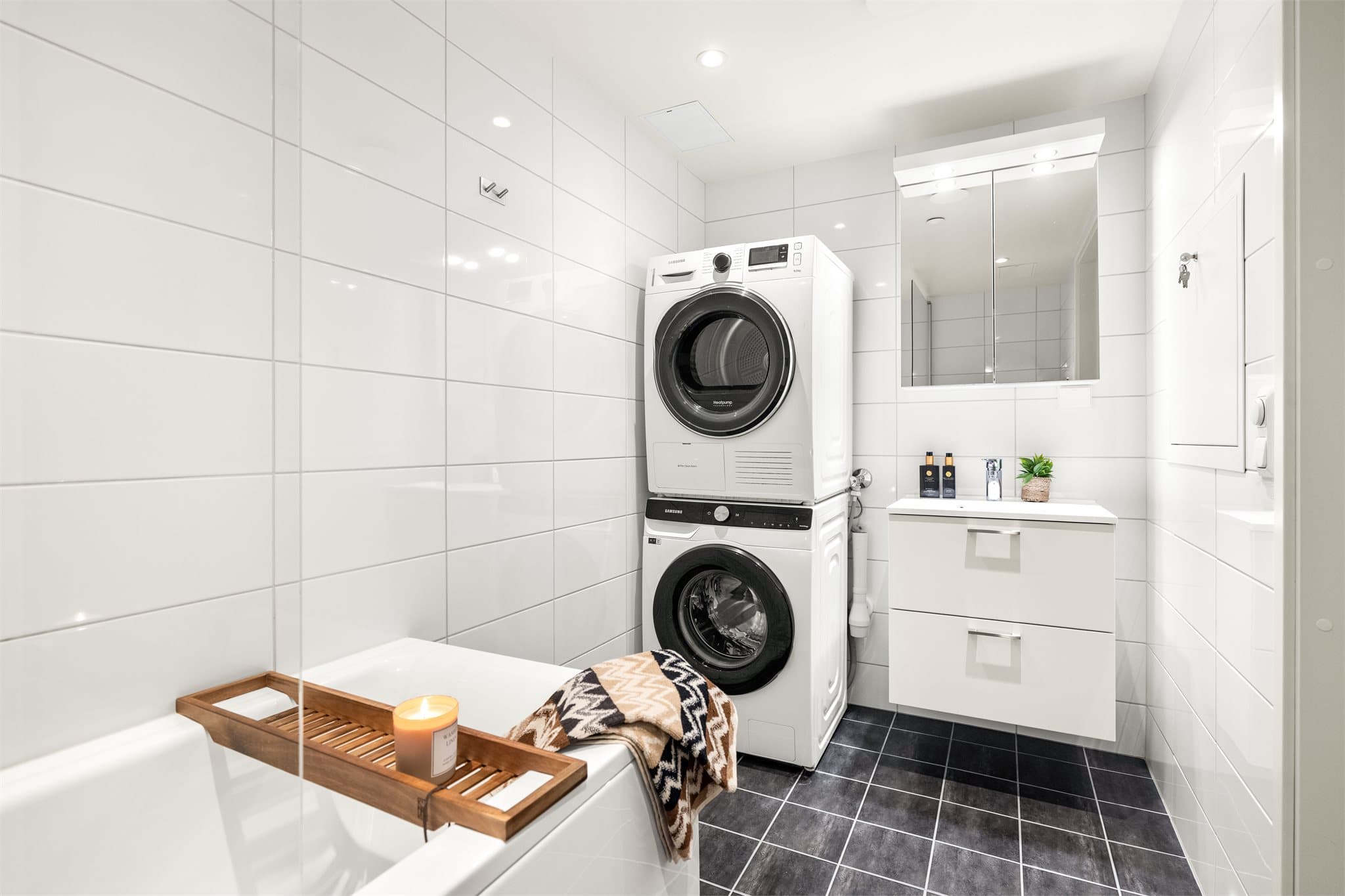 Badet er helfliset og utstyrt med badekar, vegghengt toalett og opplegg for vaskemaskin.